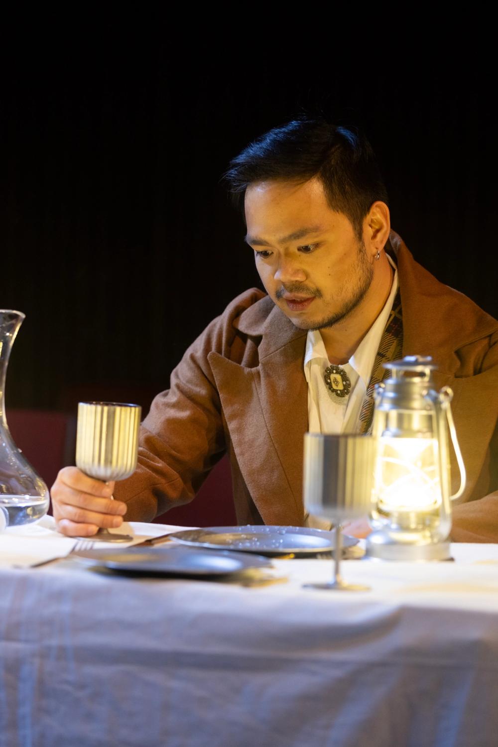 Ross sitter ved middagsbord og stirrer inn i lufta foran seg.