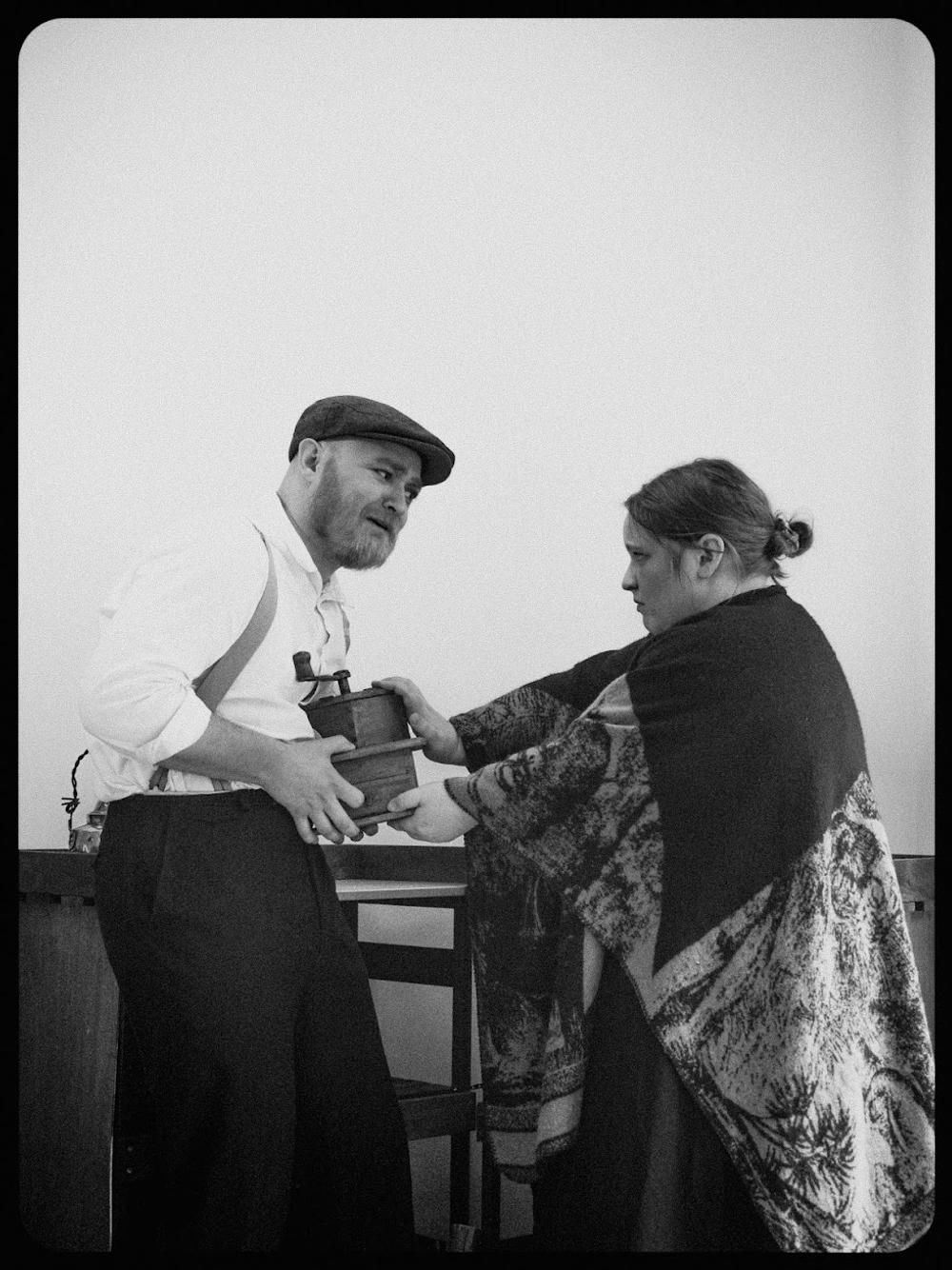 Marie som presser kaffekverna på Peter.