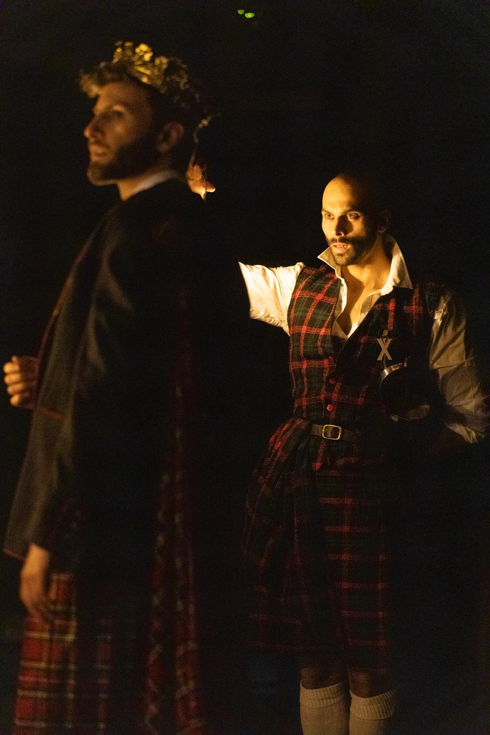 Macbeth står i mørket, bak kongen.