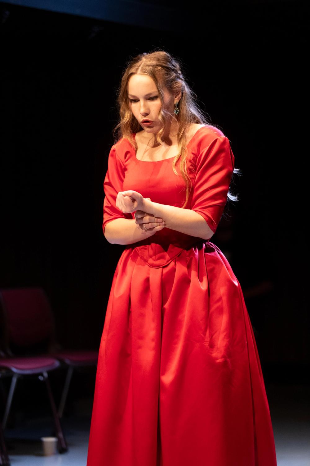 Lady Macbeth, i rød kjole, snakker til seg selv.