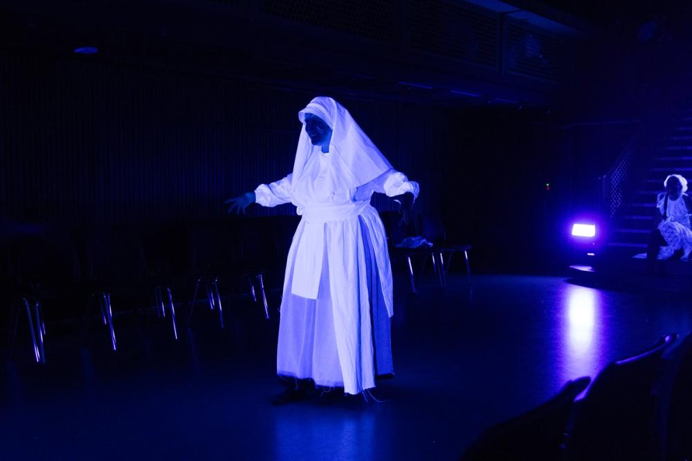 Heks med armene ut, som lyser i mørket.