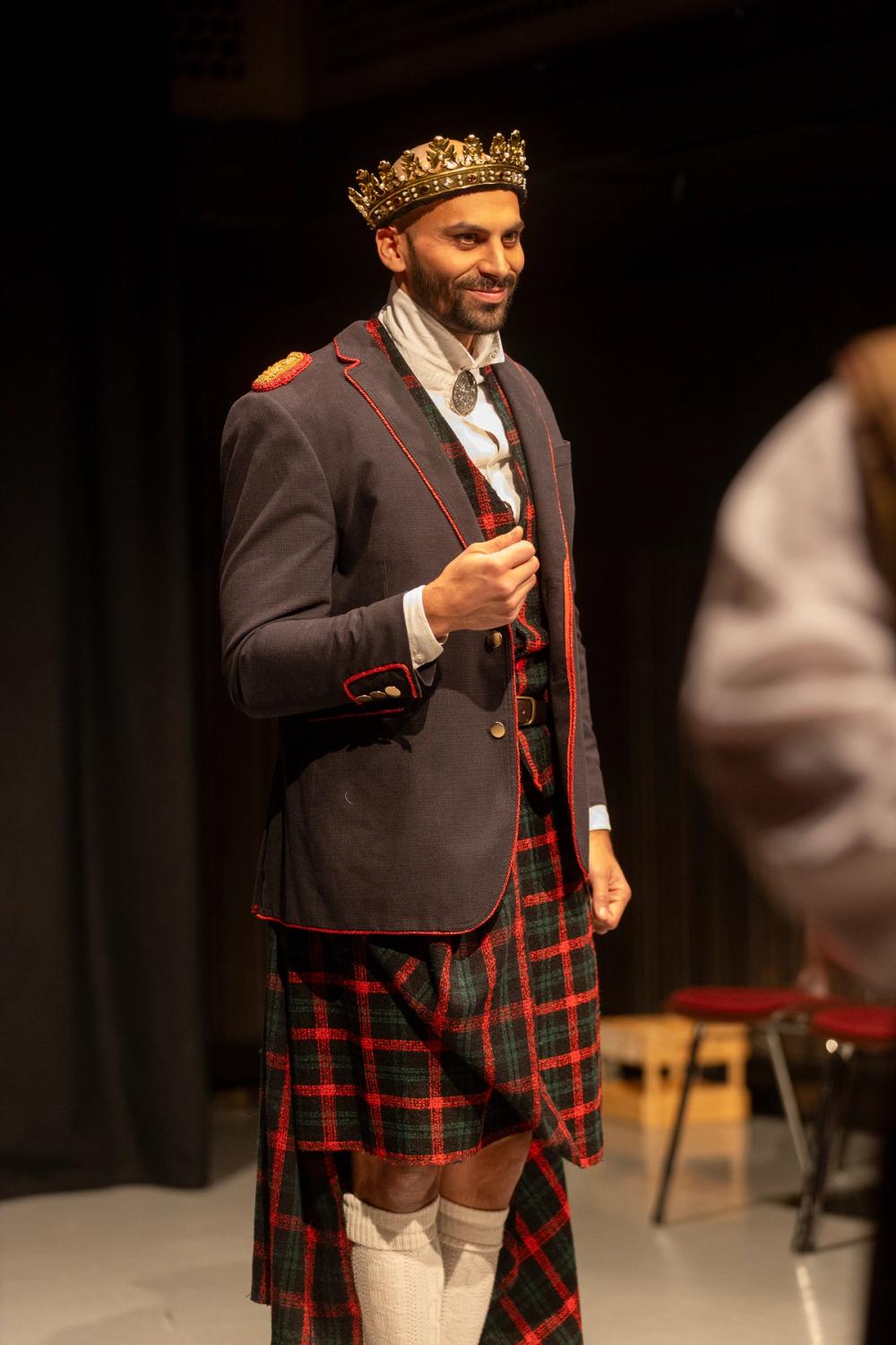 Macbeth som konge, i jakke og krone.