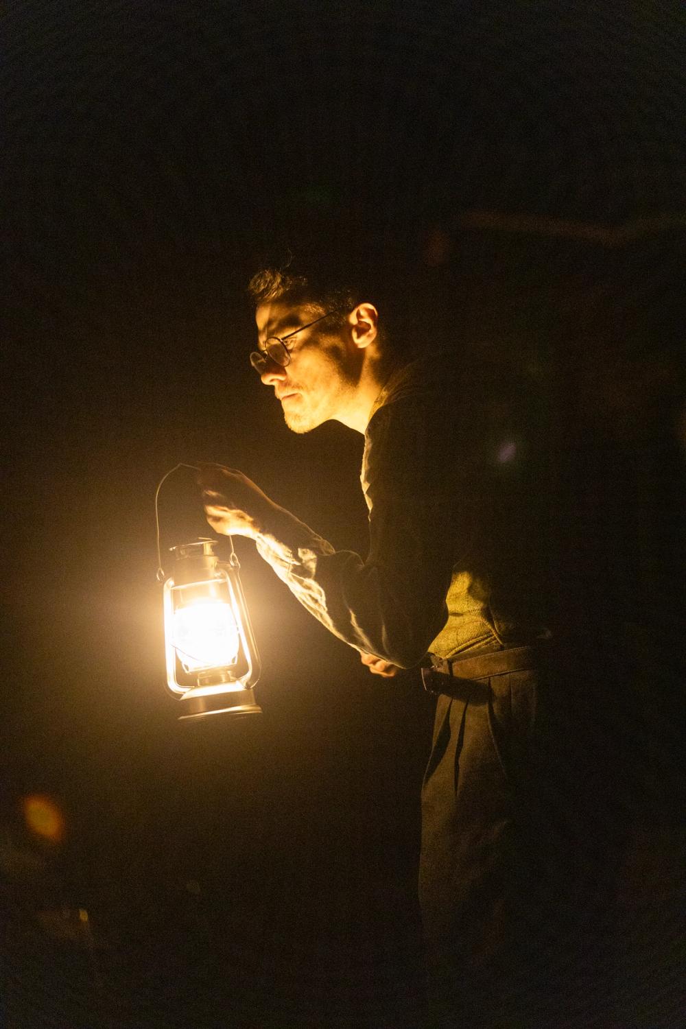 Krokrygget lege med en lykt i mørket.