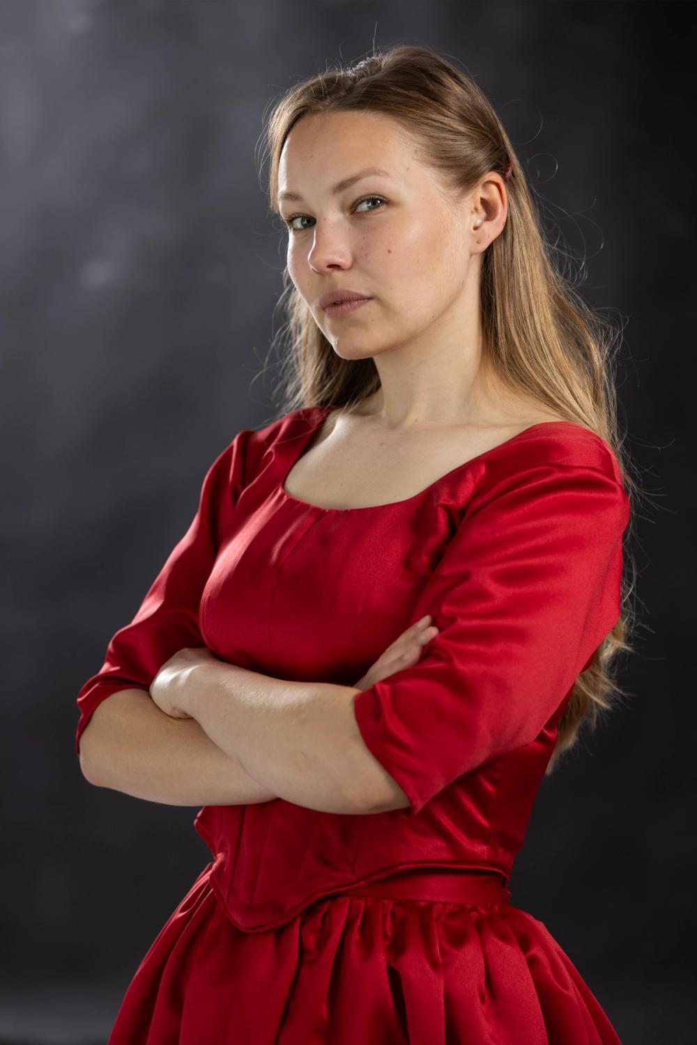 Kvinne i rød kjole med armene krysset