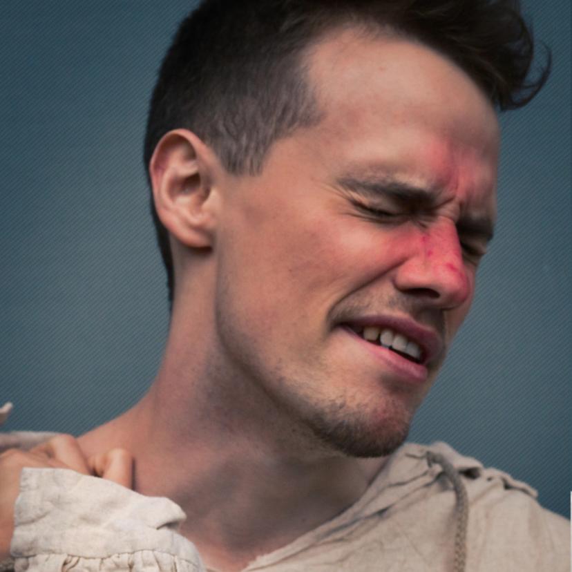 Portrettbilde av en fyllik med rød nese som har øynene lukket og ser ut som han kan sovne når som helst.