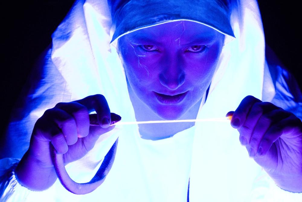 Tredje heks stirrer inn i kamera og drar av tungen på en liten slange.