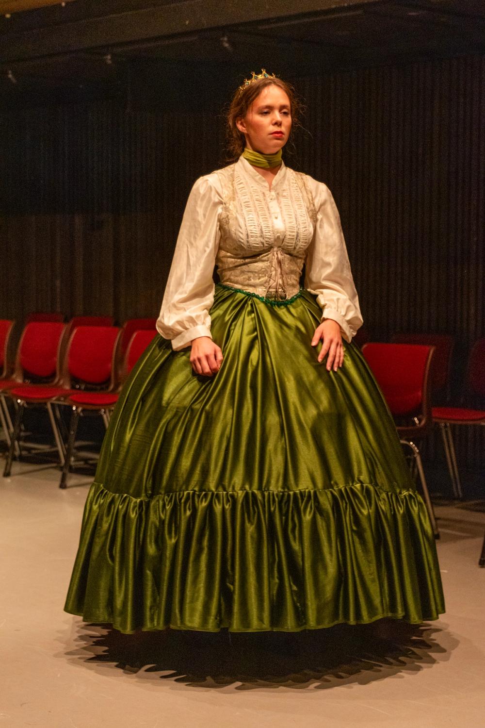 Prinsesse Mary står midt på gulvet, i ballkjolen sin, alene.