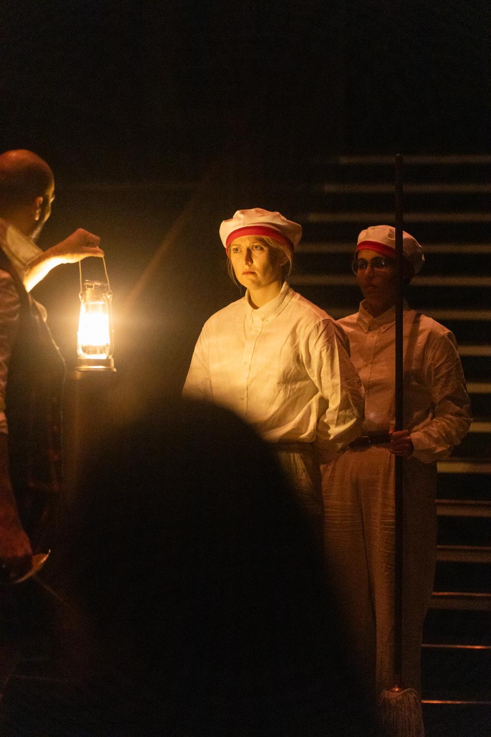 Matroser som blir lyst opp av en lykt Macbeth holder.