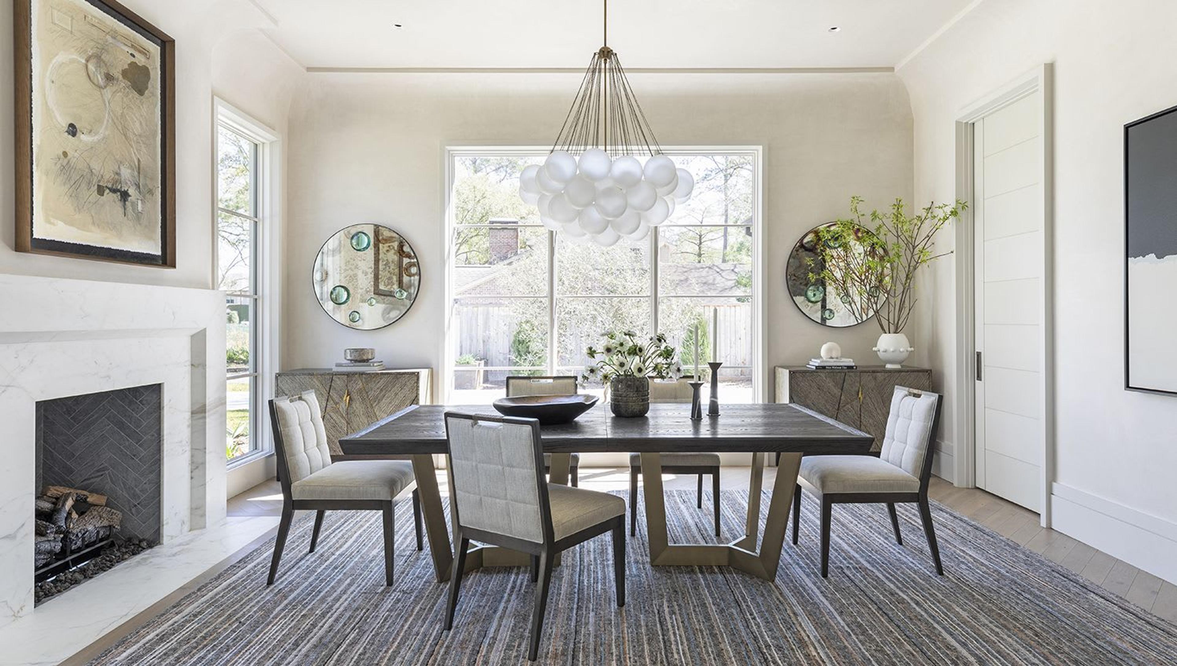 In this dining room, a cloud-like fixture of chain link and hand blown glass sets a soft, welcoming tone. Diamond plaster walls, a custom cove molding, and furnishings with unique, unexpected forms infuse drama by playing with balance and composition.