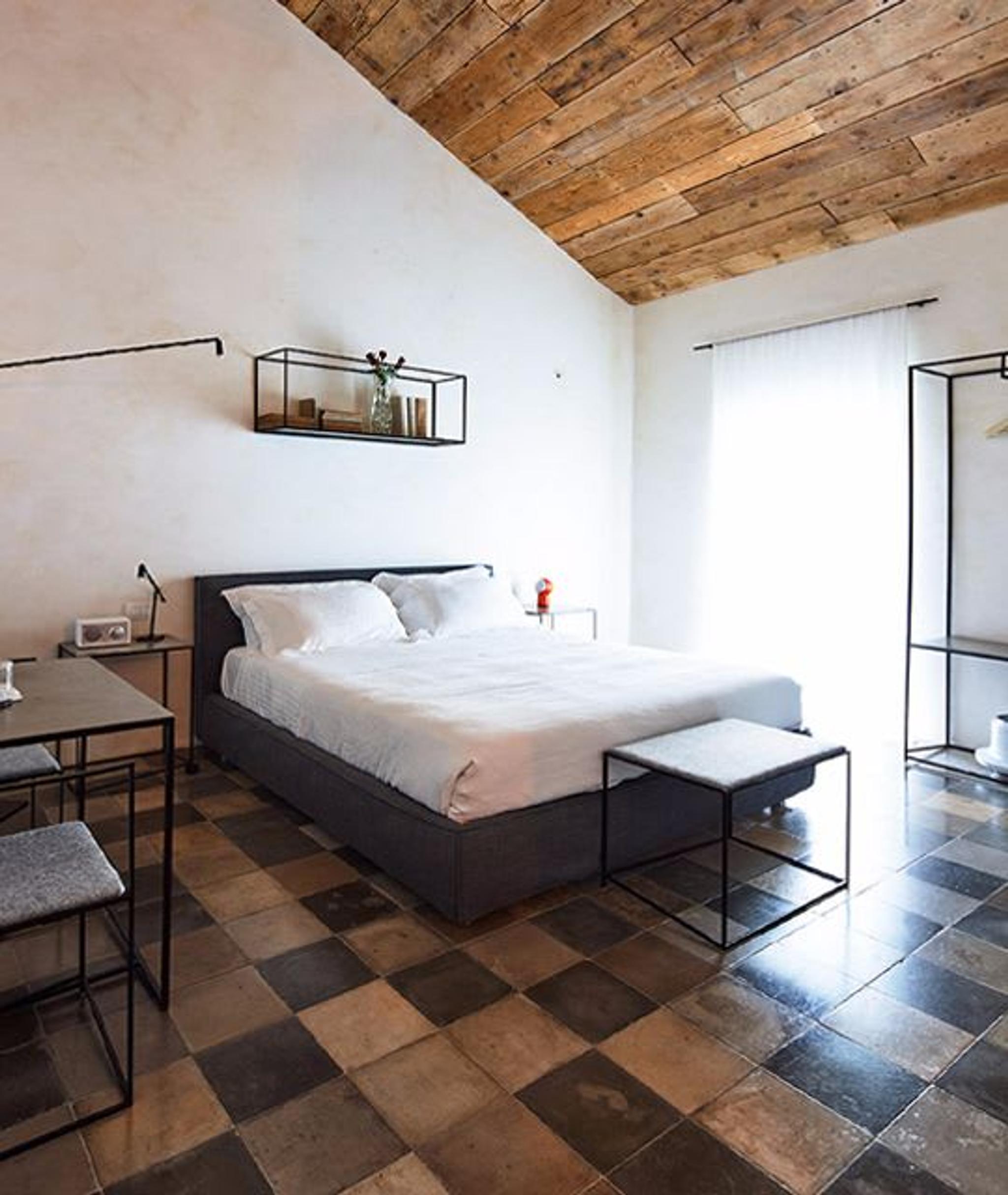Soffitti in legno e pareti bianche si combinano per creare un'atmosfera essenziale e rilassante.