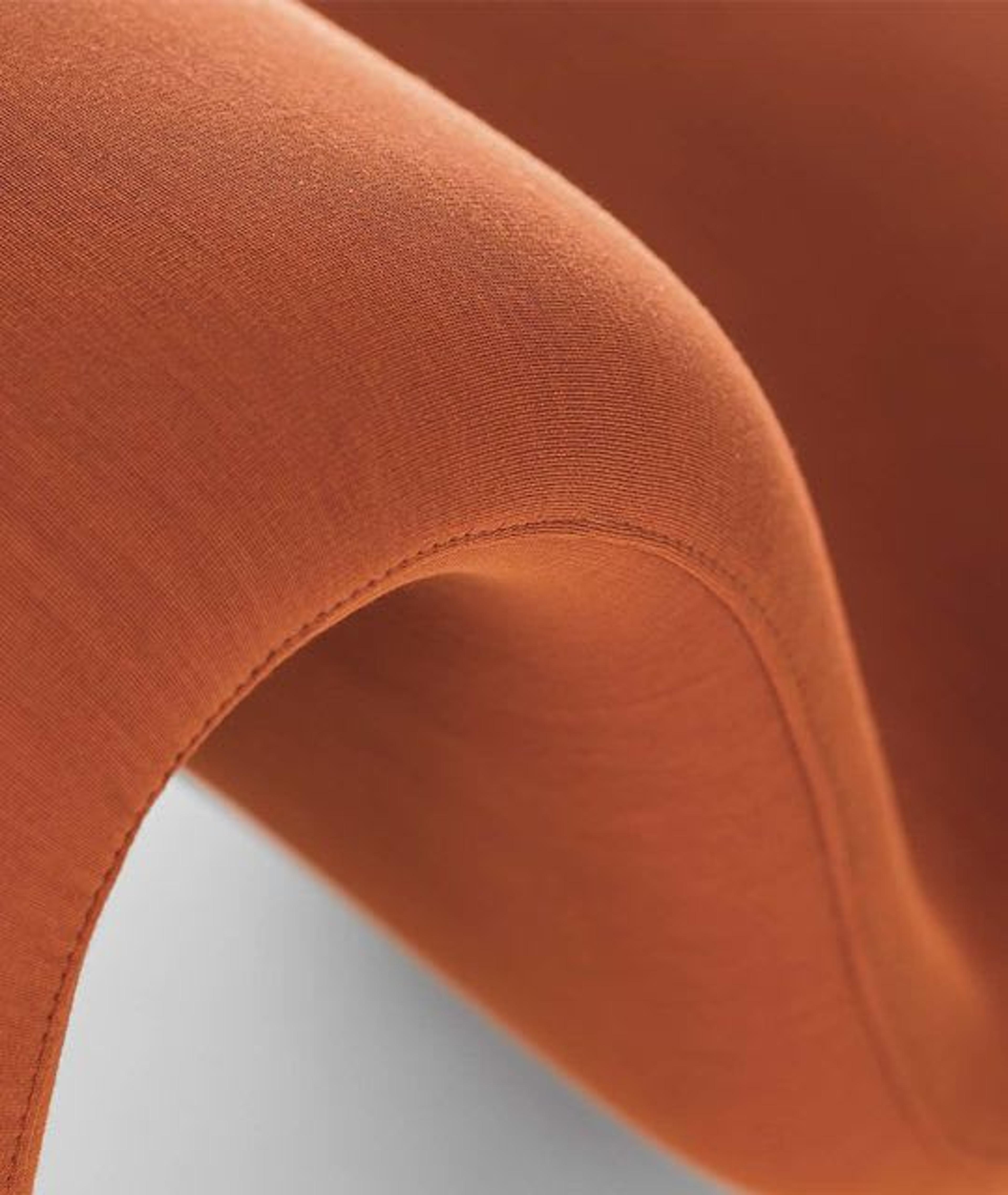 Detalles curvados de la silla doble naranja Dos à Dos Louvre de La Cividina