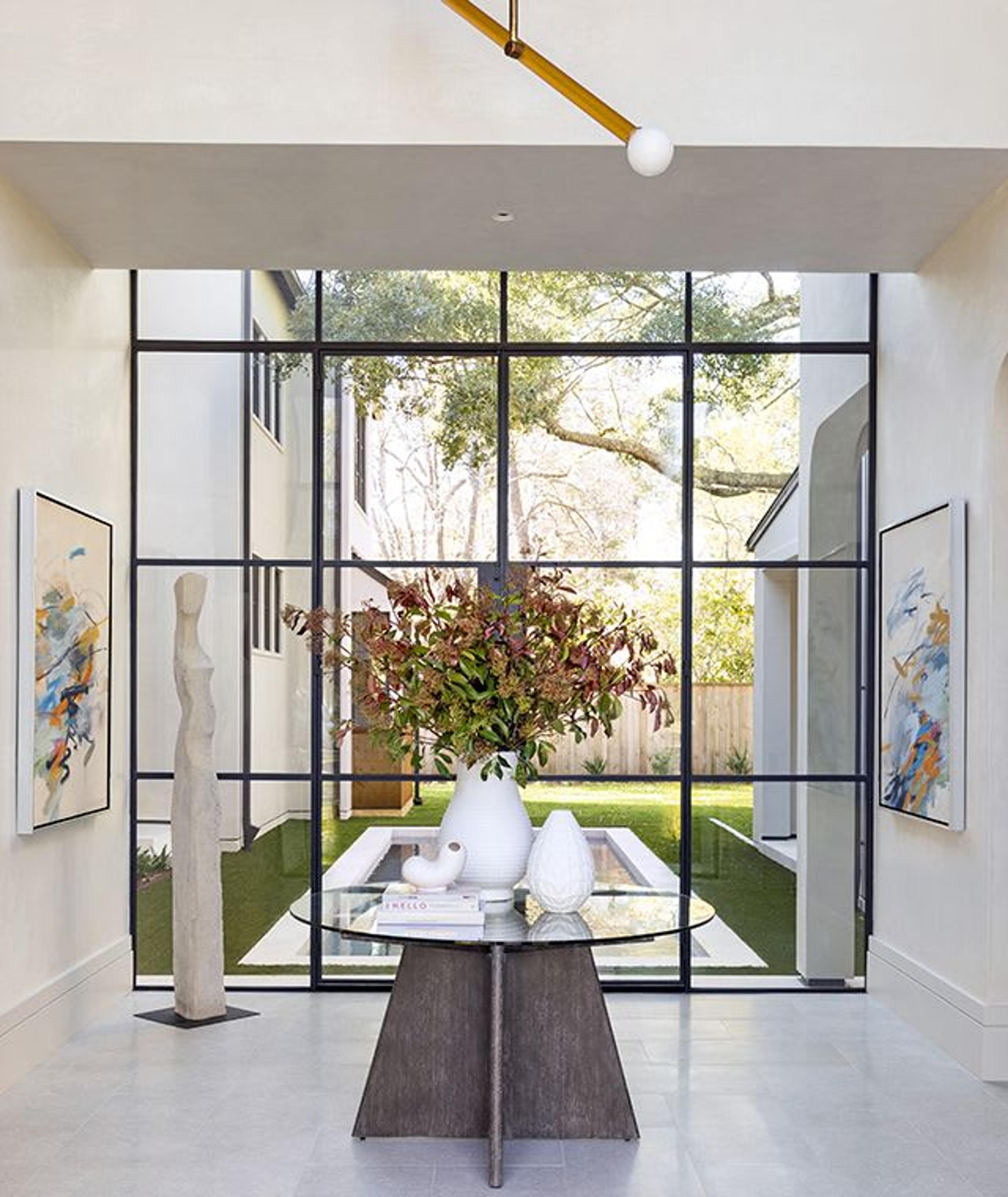 With diamond plaster walls, porcelain flooring, and steel doors that frame the pool and surrounding grounds, this dynamic foyer invites natural light to flood into this Piney Point Village home.