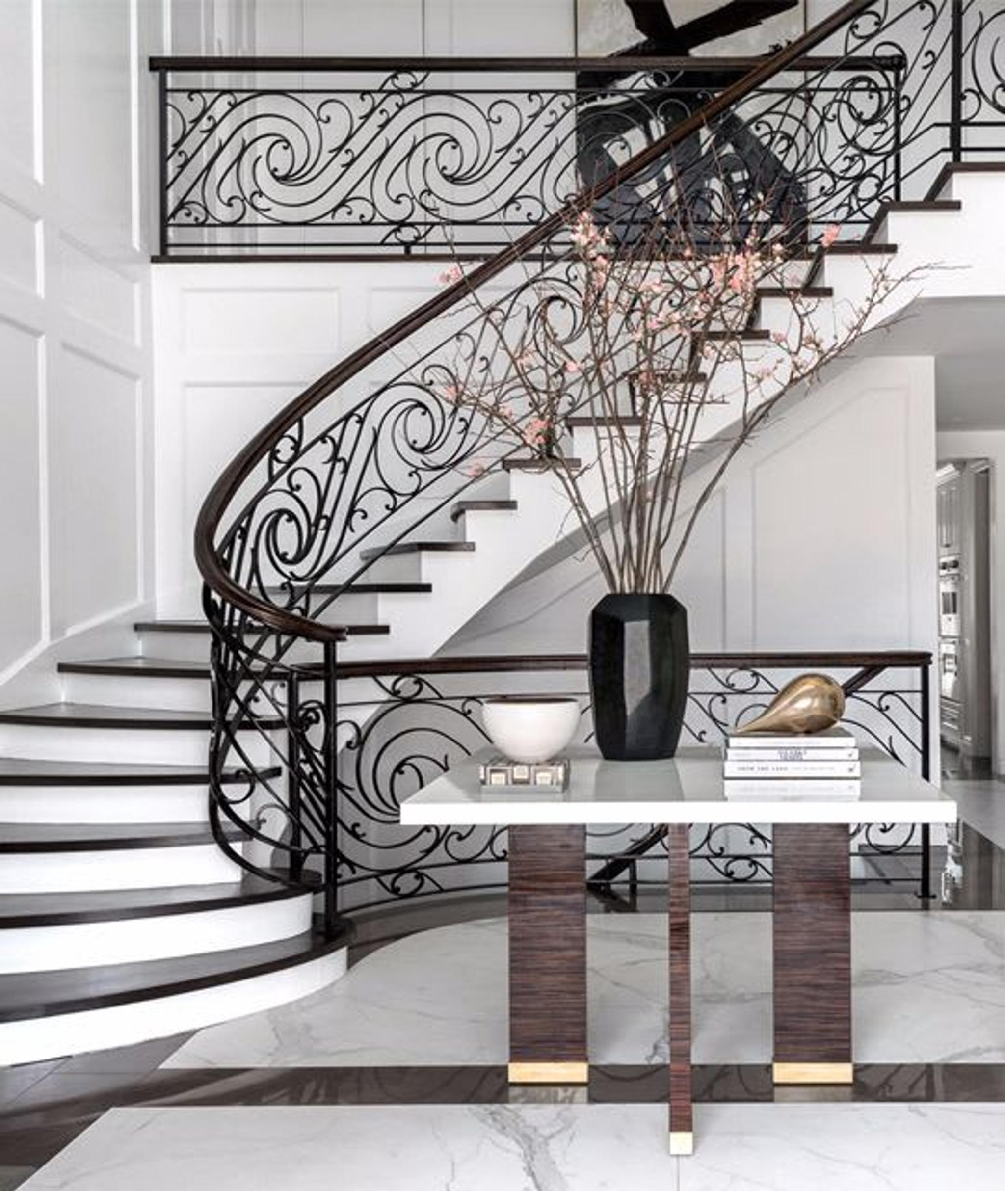 Regal staircase and entryway décor of the refined New Jersey residence decorated by Jordan Carlyle