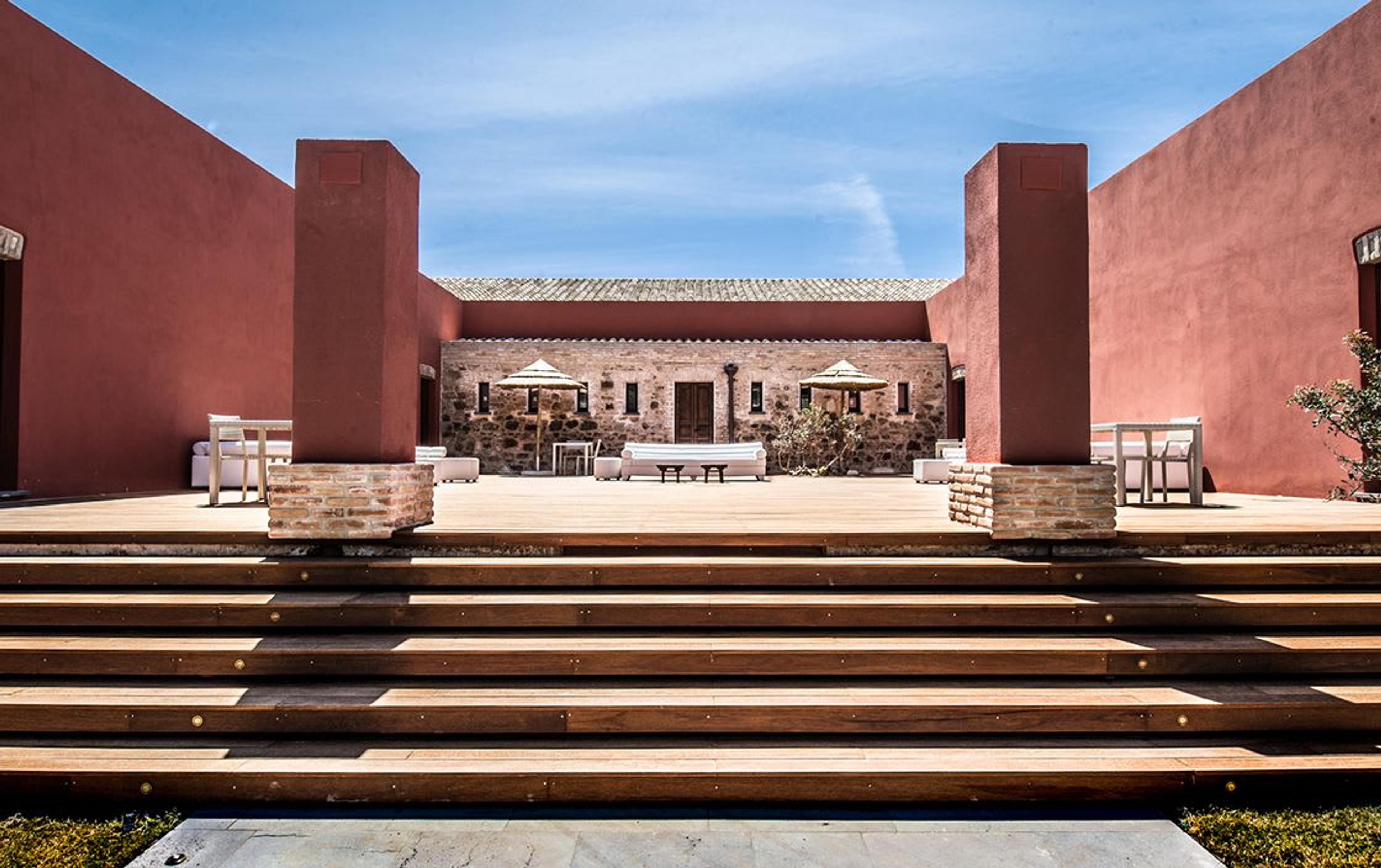 Wooden deck that welcomes the guests to Faro Capo Spartivento hotel in Sardinia