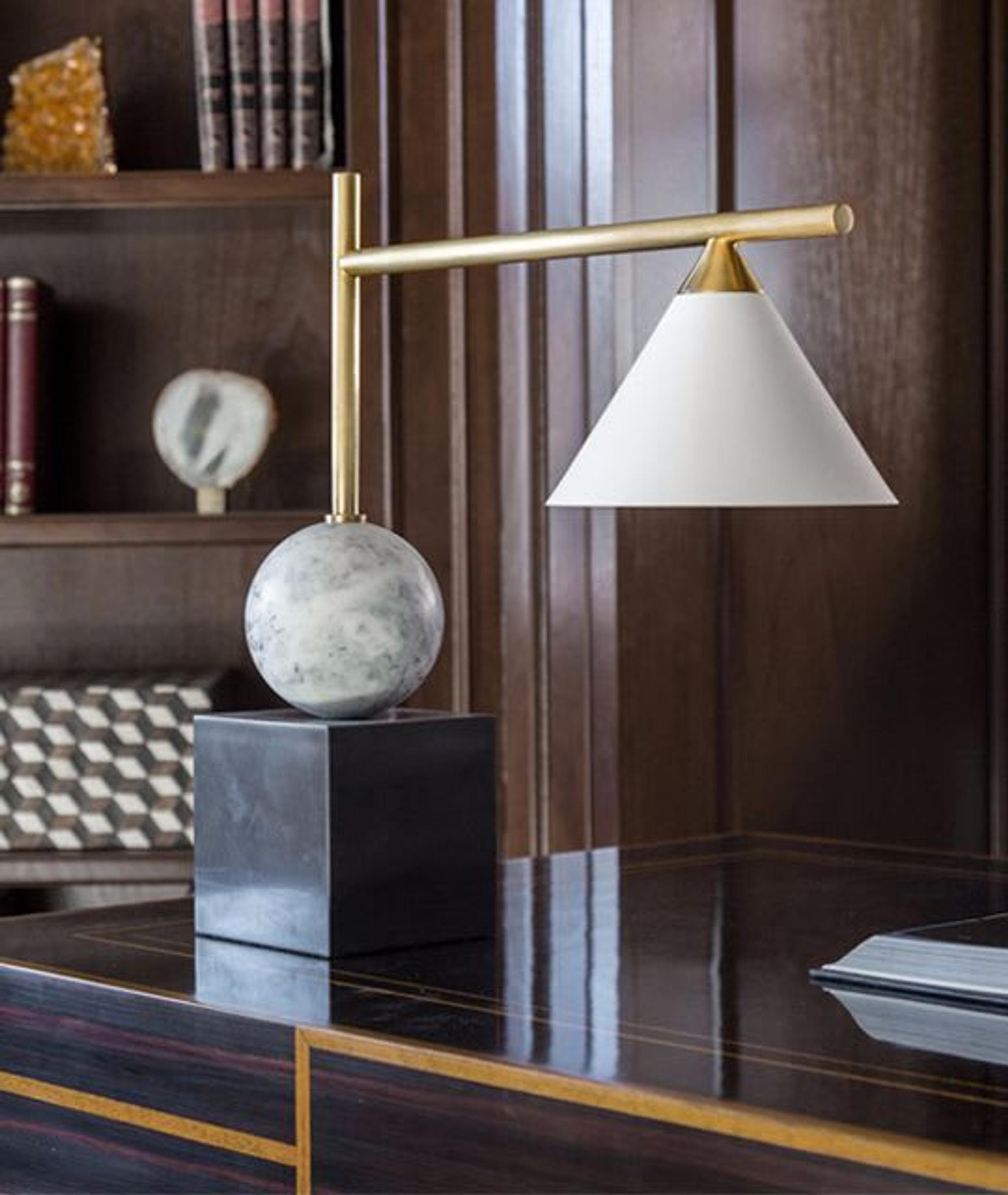 Lámpara de mesa de bonito diseño colocada sobre el escritorio de esta encantadora oficina doméstica de Jordan Carlyle.