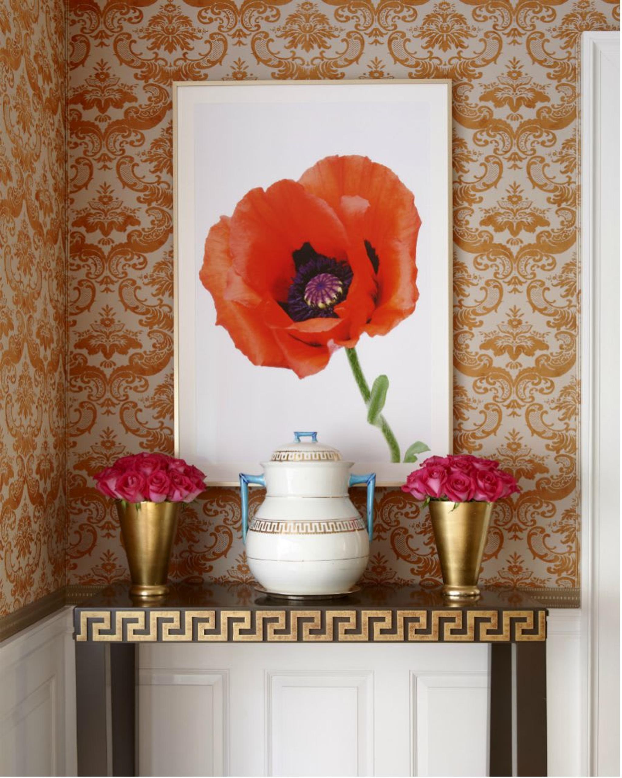 A poppy paintings beautifully layered on the classic wallpaper on the tones of a warm orange.