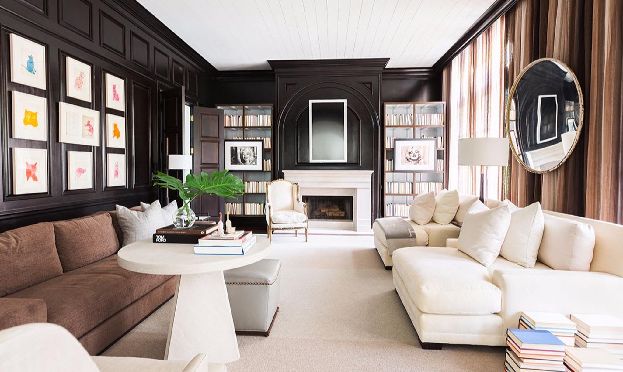 In this study, the walls were given a charred effect by staining them with burl walnut many times over. The round mirror on the right wall was salvaged from a local grocery store, while Andy Warhol’s original sketches of cats are displayed on the left to bring juxtaposition to the room.Photo by Alyssa Rosenheck