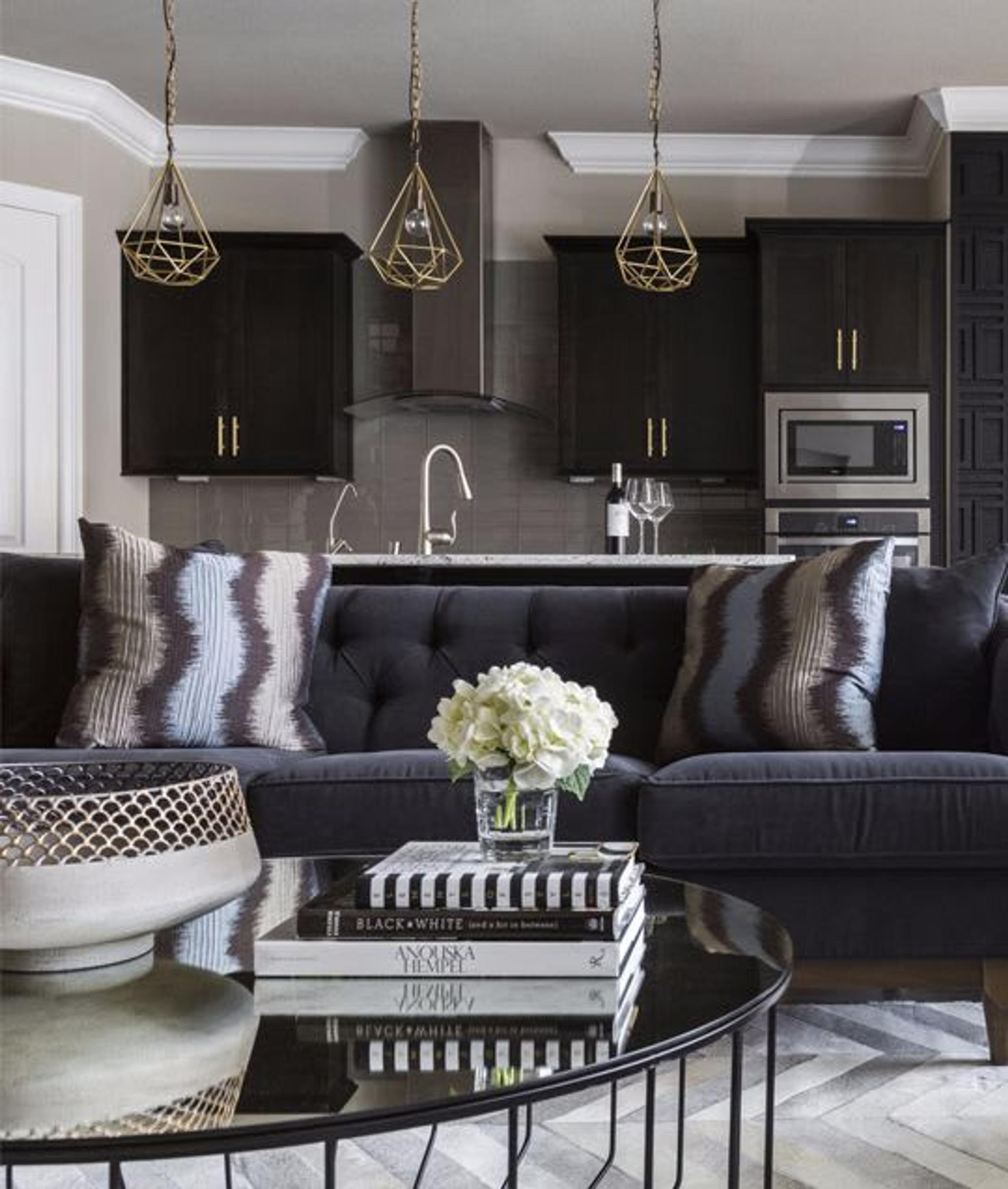 Anstelle von Edelstahl wurden der schwarzen Küche goldene Akzente hinzugefügt, um eine farbenfrohe Palette zu schaffen, die anspruchsvoll und dennoch einladend wirkt.