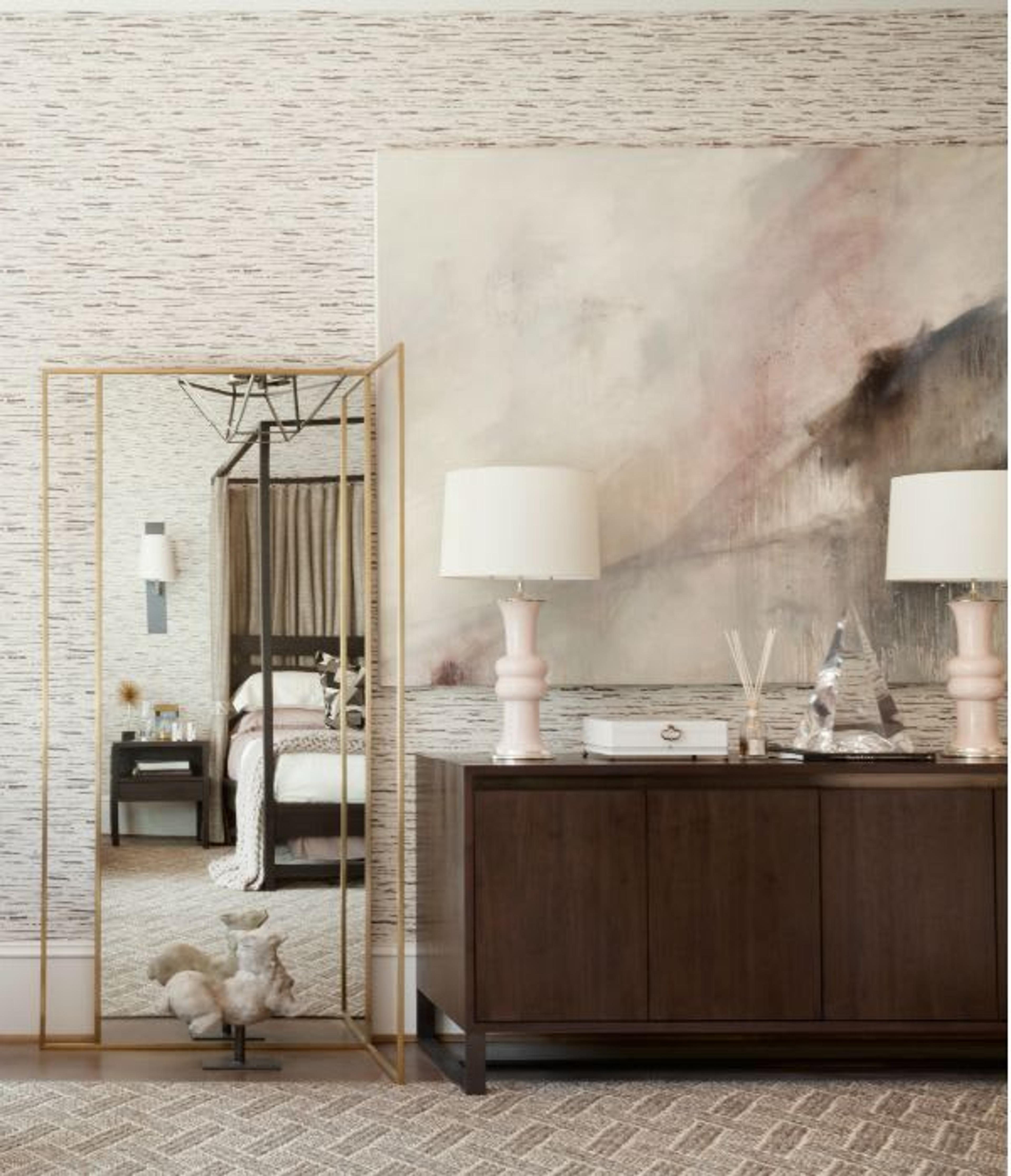 Abstract art, ceramic table lamps and a modern mirror with brass finishes - Details of bedroom decor by Jonathan Savage.