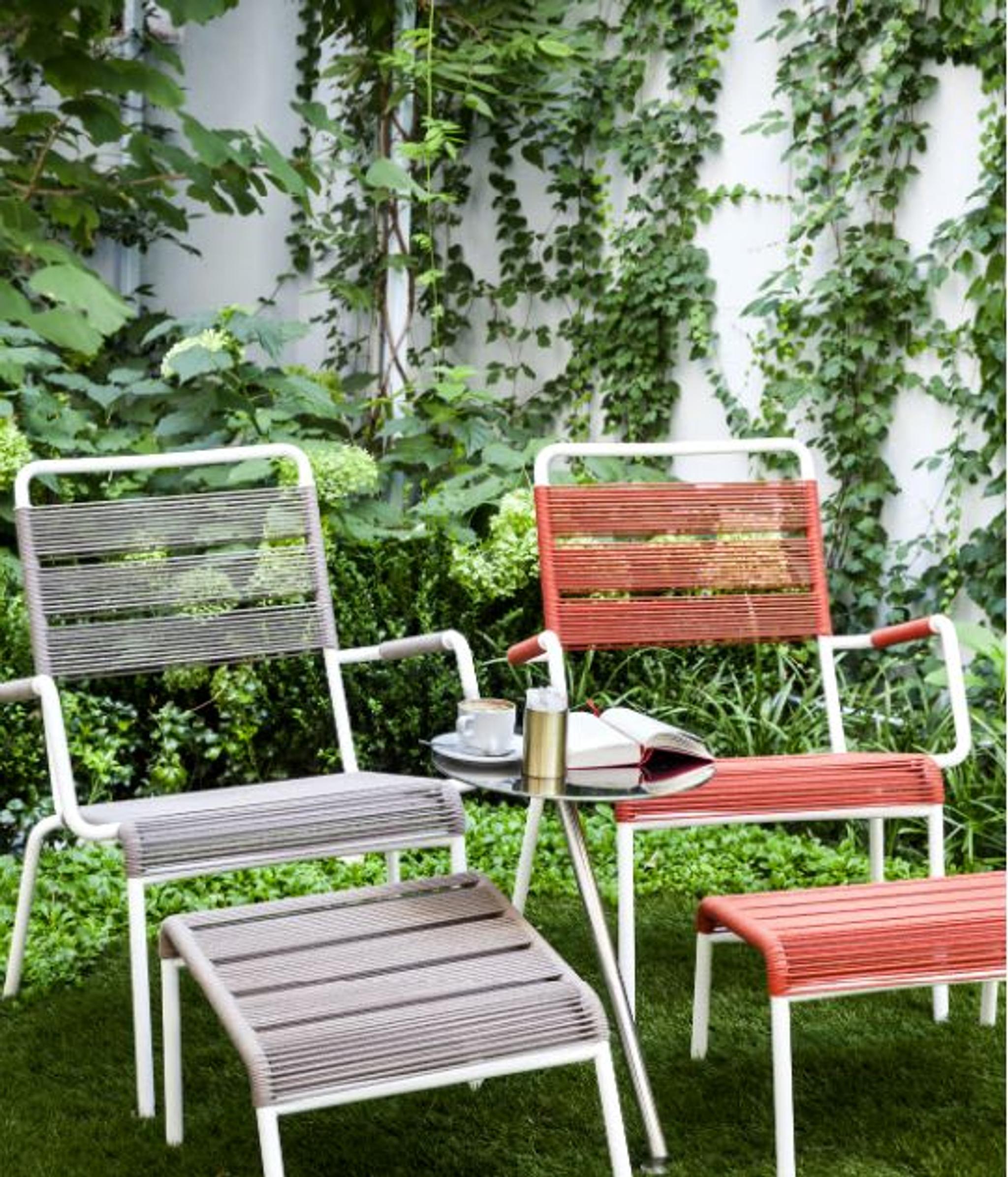 Colorful outdoor chaise longues surrounded by hydrangea and ginkgo biloba trees.
