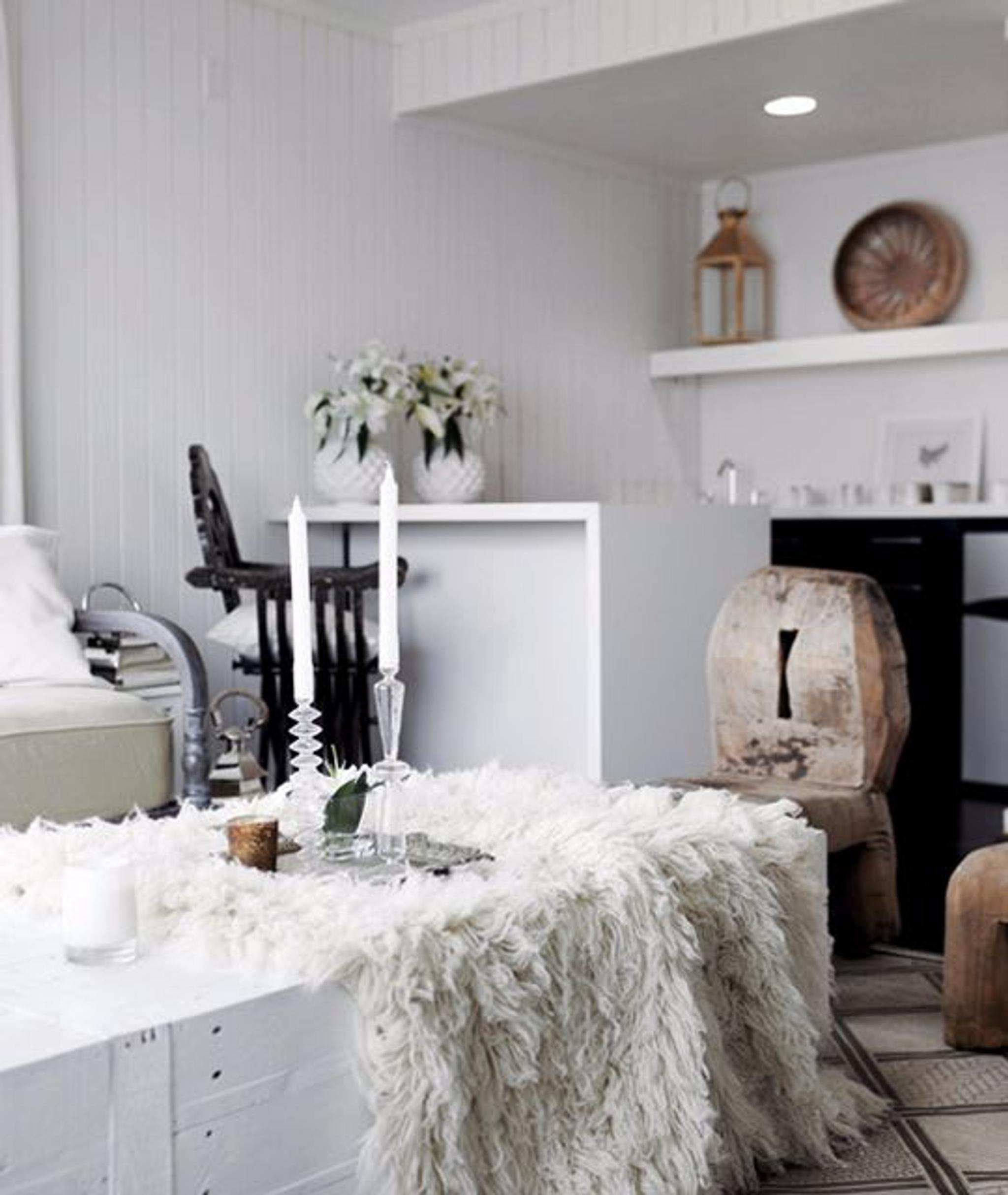 The living room of this beach house Nina help design for American Dream Builders exudes comfort and warmth. The neutral color palette combined with the sculptural forms of the chairs and the rich textures of the throw create a beautiful rustic space.