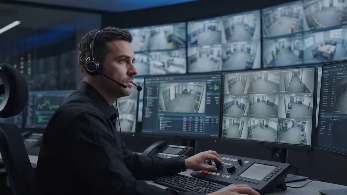 Controller wearing a headset watching live camera feeds on a monitoring wall
