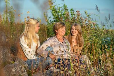 Drie vrouwen lachend zittend in het gras