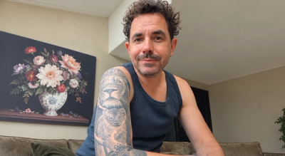 Een man ontspannen zittend met leeuwentatoeage op de arm