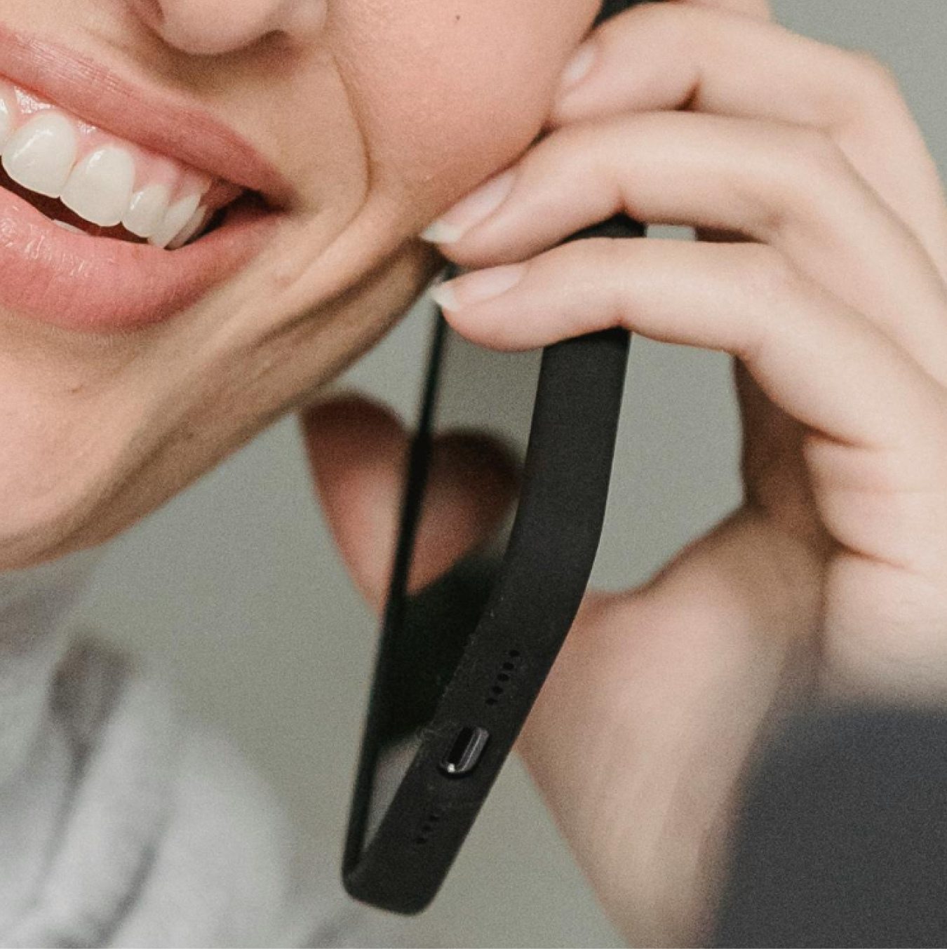 Close-up of a smiling person talking on a smartphone.