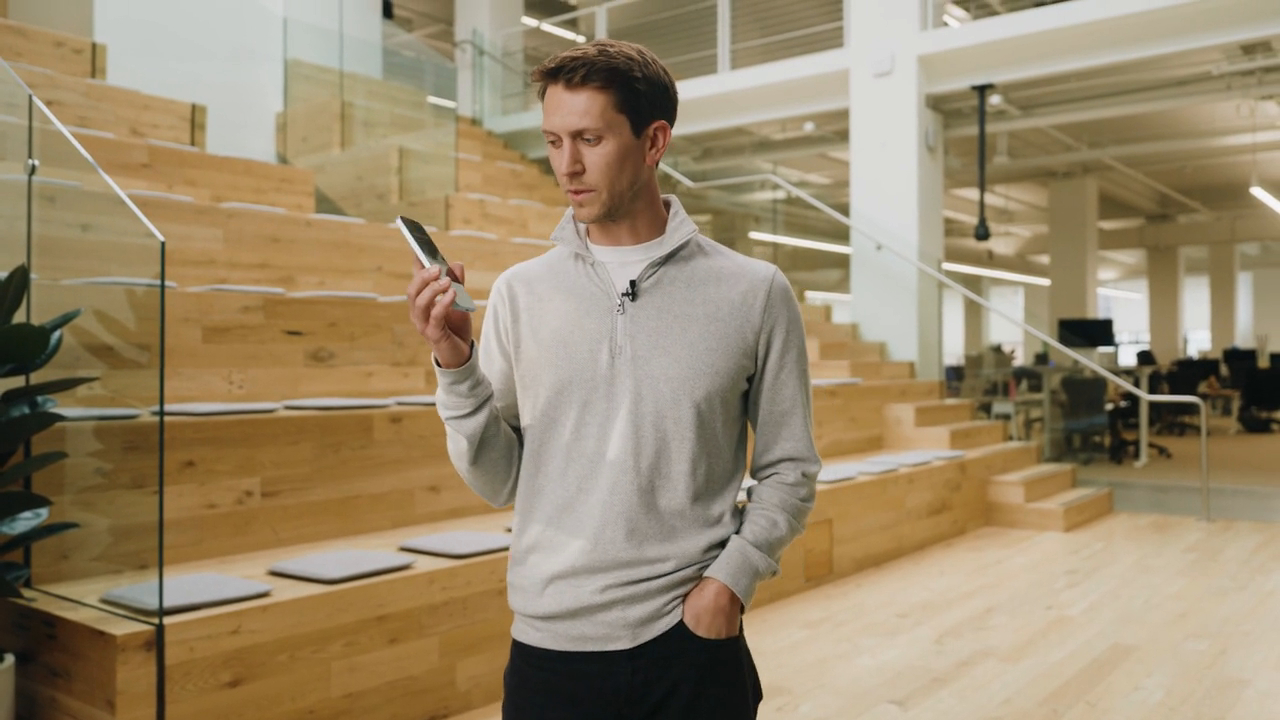 Man in office holding a phone