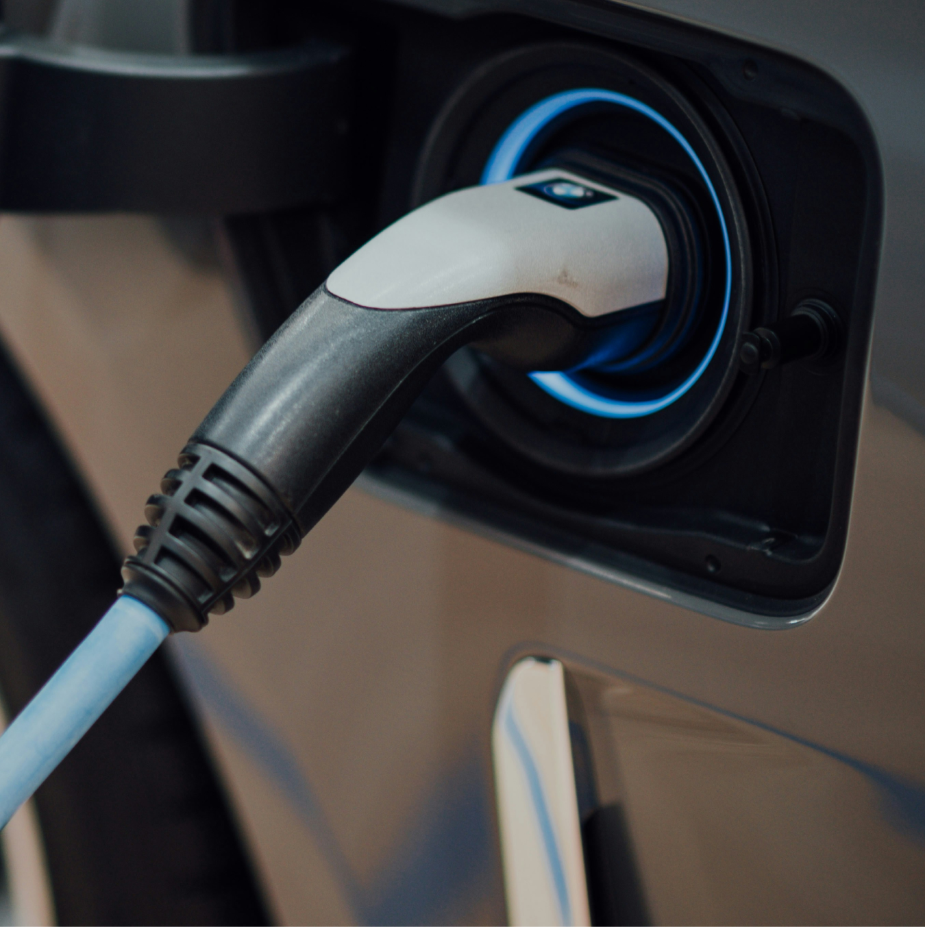 Electric car charging port glowing blue.