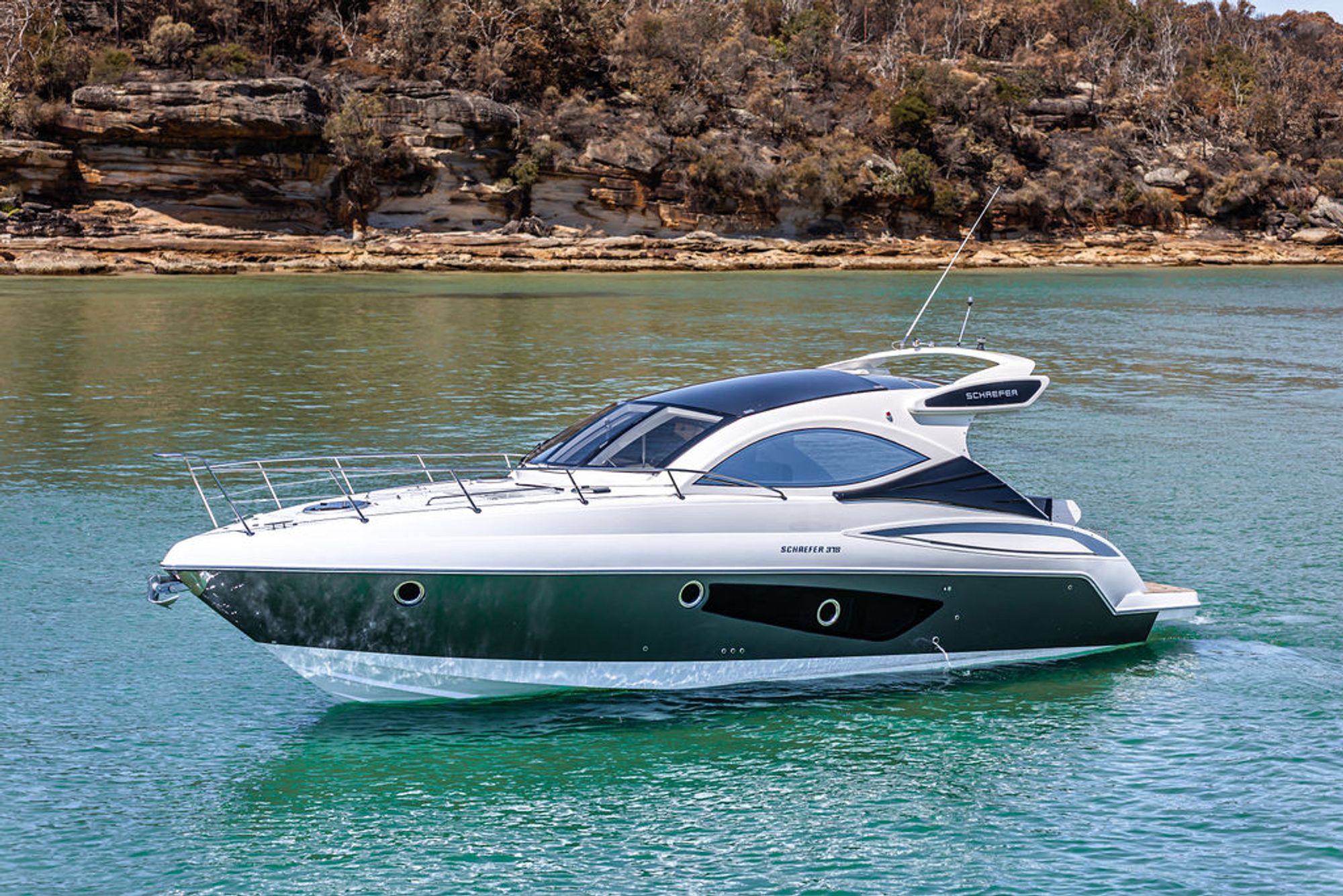 Schaefer sports cruiser at anchor beneath sandstone cliffs