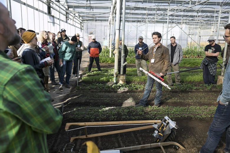 Picture of a group of men and women in a greenhouse 