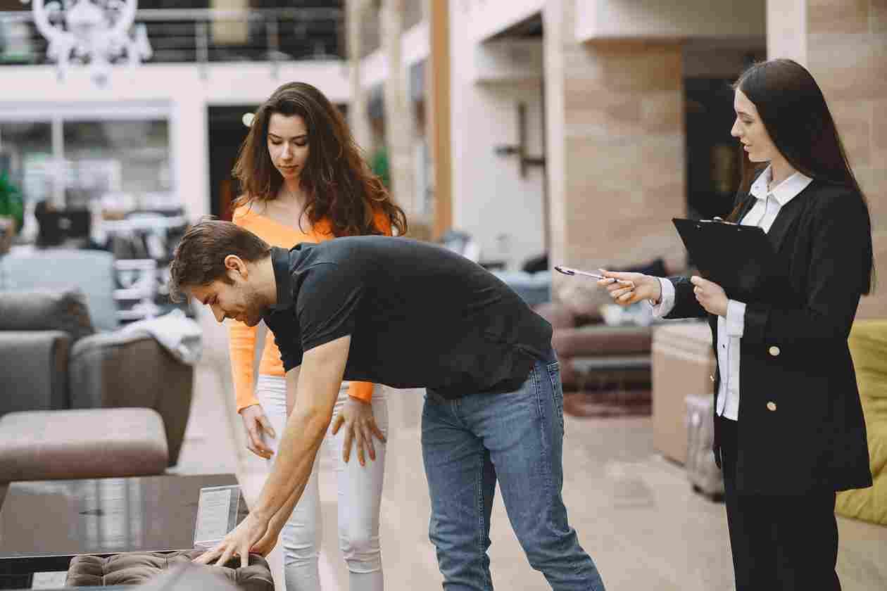 Exploring furniture warranties with a consultant and potential buyers in-store.