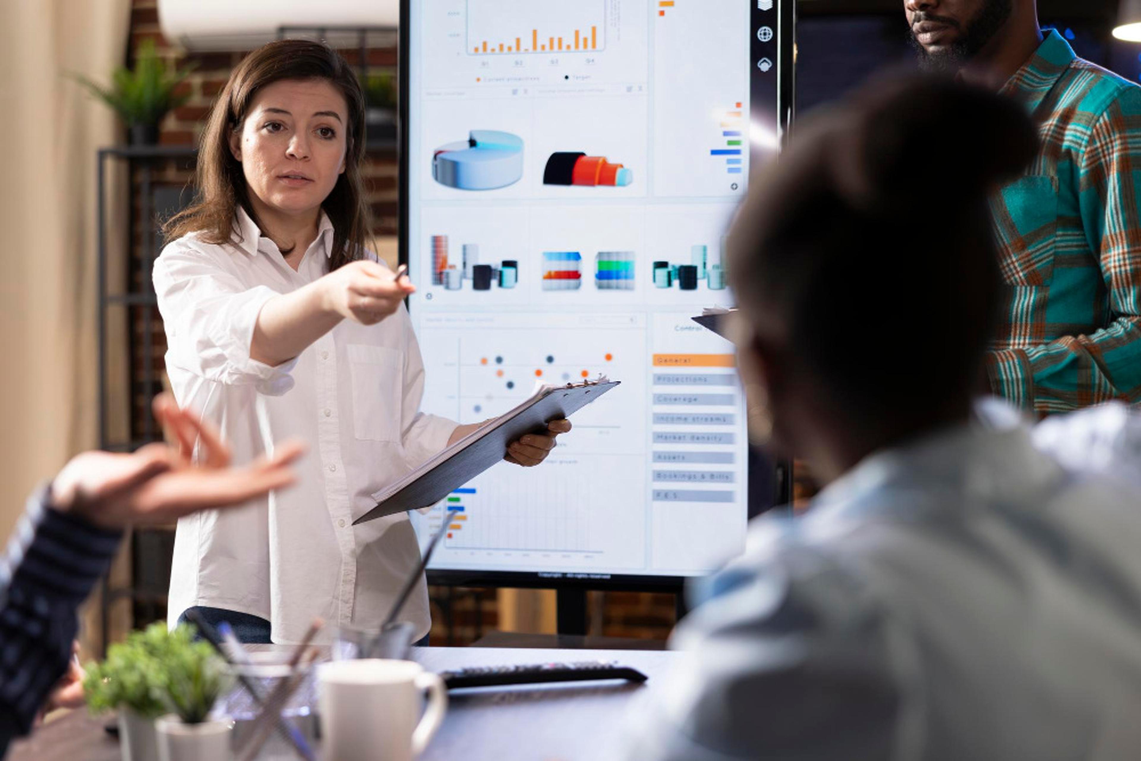 Team discussing customer feedback strategies with data visuals in a professional setting.