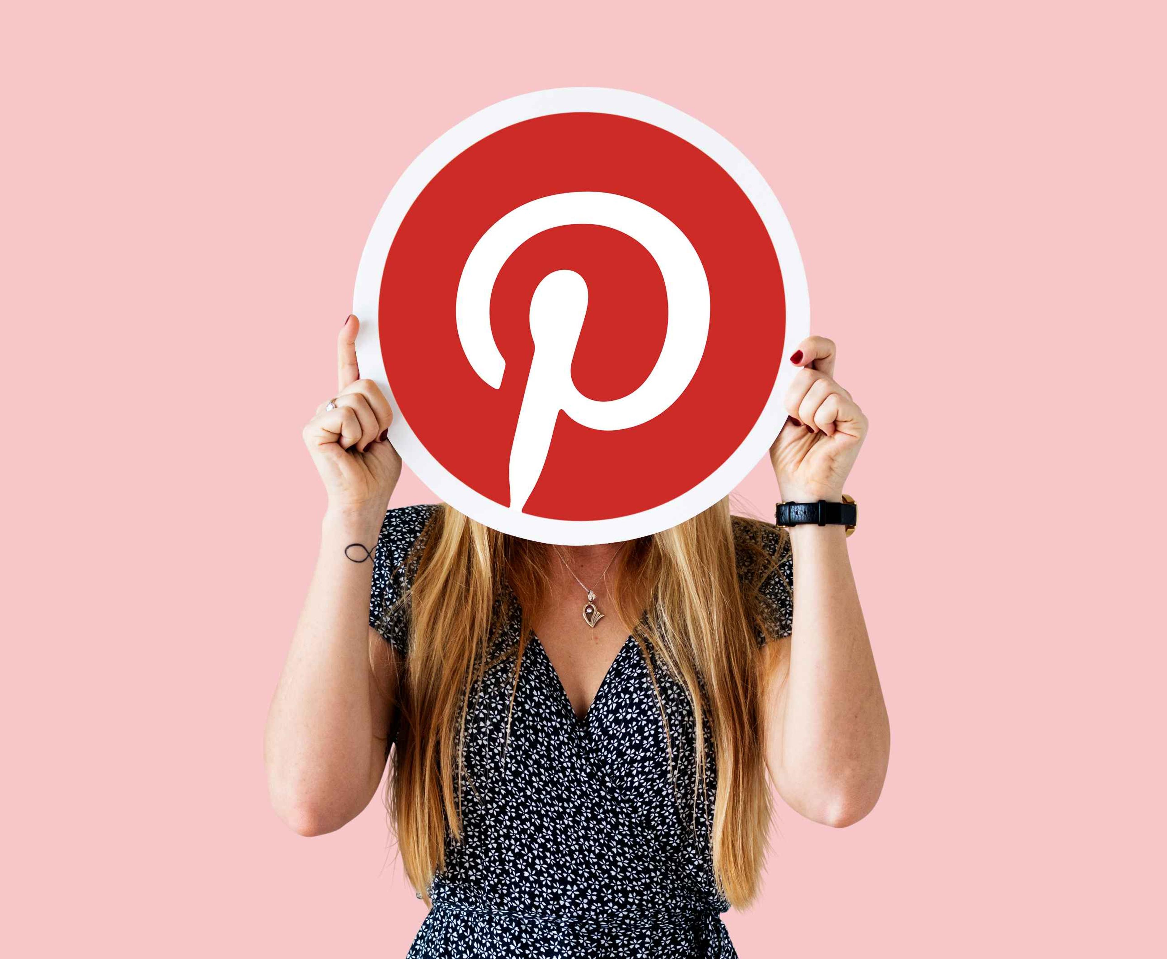Person holding Pinterest logo, representing pre-commerce strategies for online success.