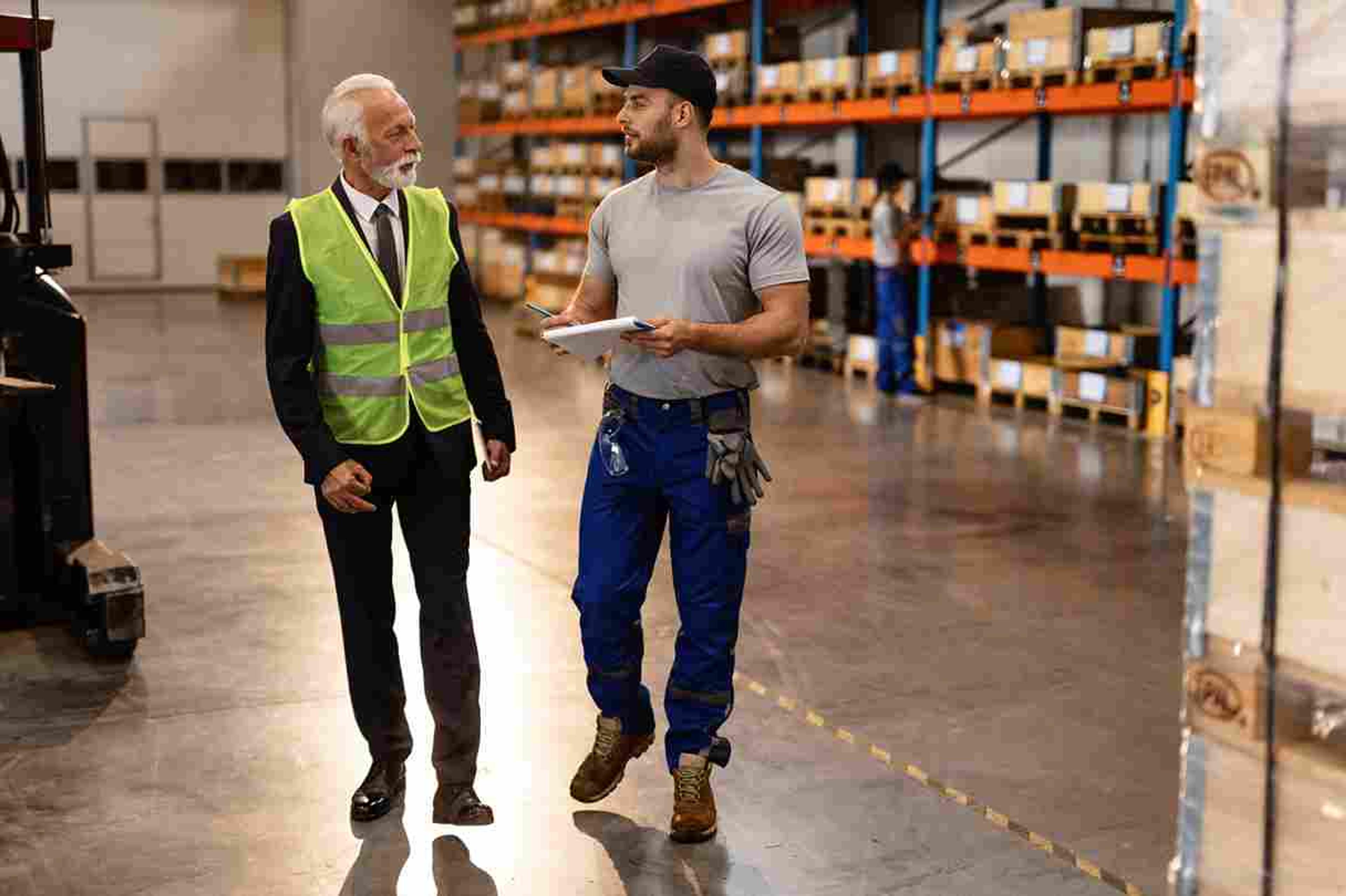 Professionals discussing sourcing strategies in a warehouse environment for 2025's challenges.