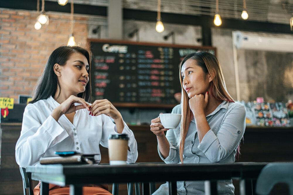 Ecommerce merchants discussing strategies for tariff-driven price increases over coffee.