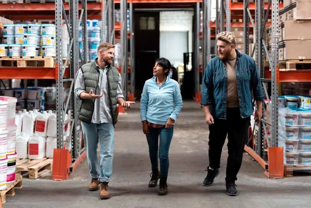 Professionals discussing supply chain strategies in a warehouse for business growth.