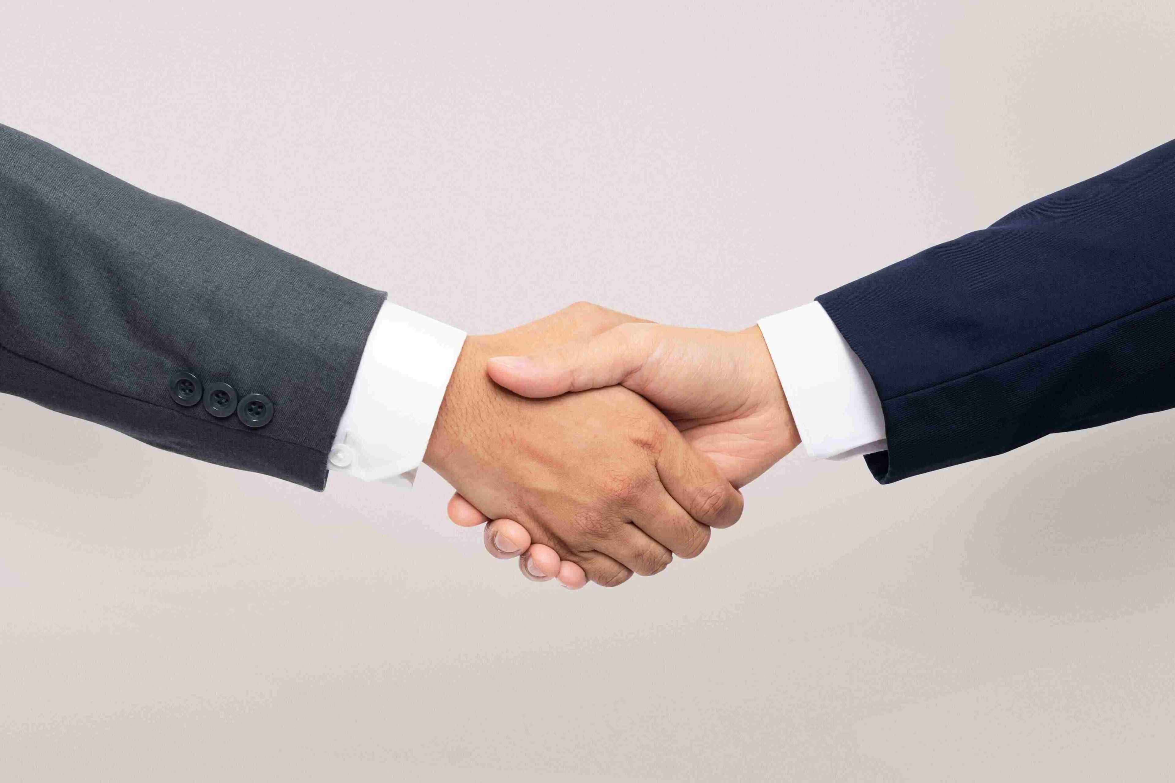 Professional handshake representing new warranty launch for custom installers at CEDIA Expo 2025.