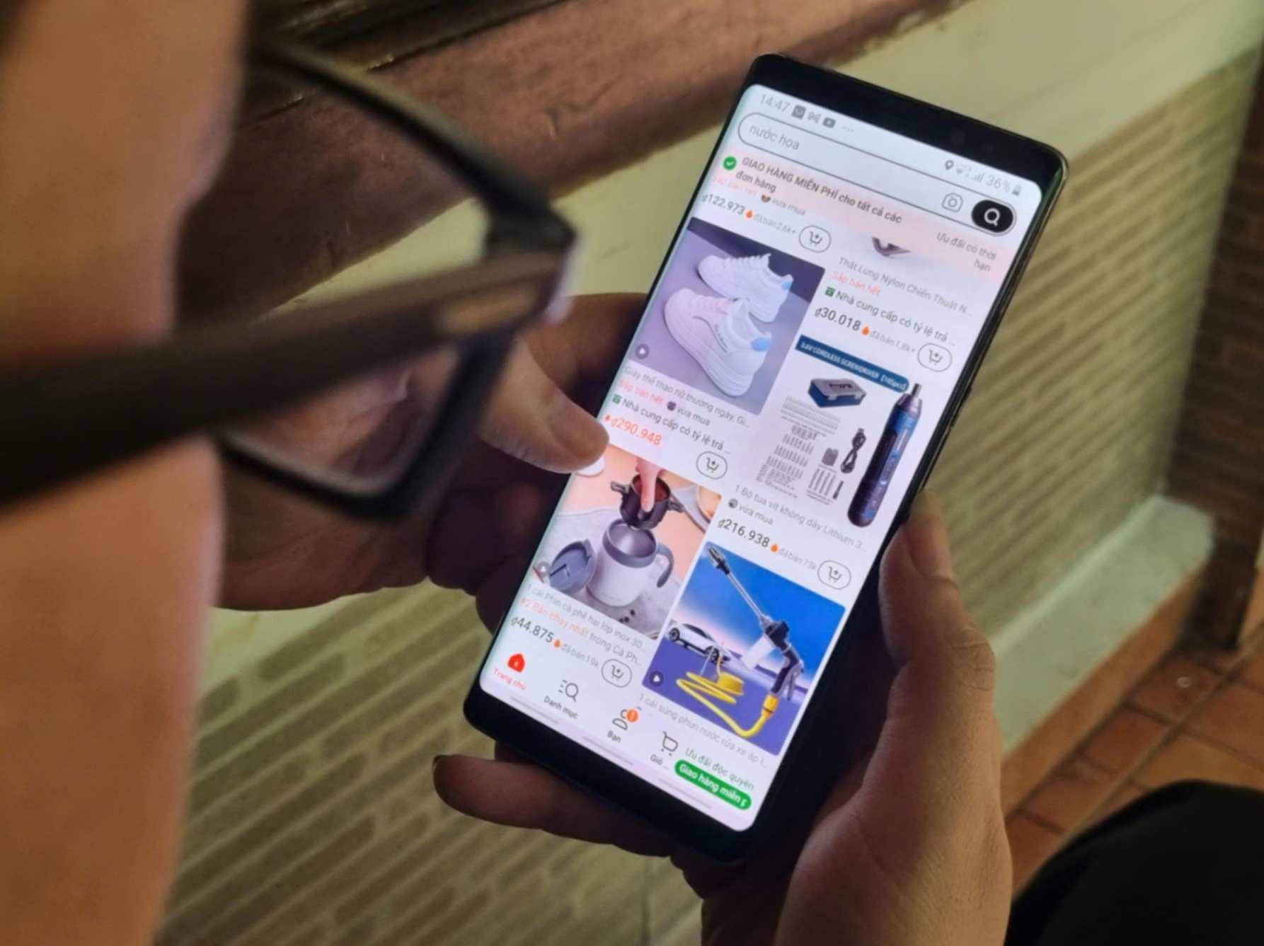Shopper browsing product listings and prices on an e-commerce shopping app on a smartphone