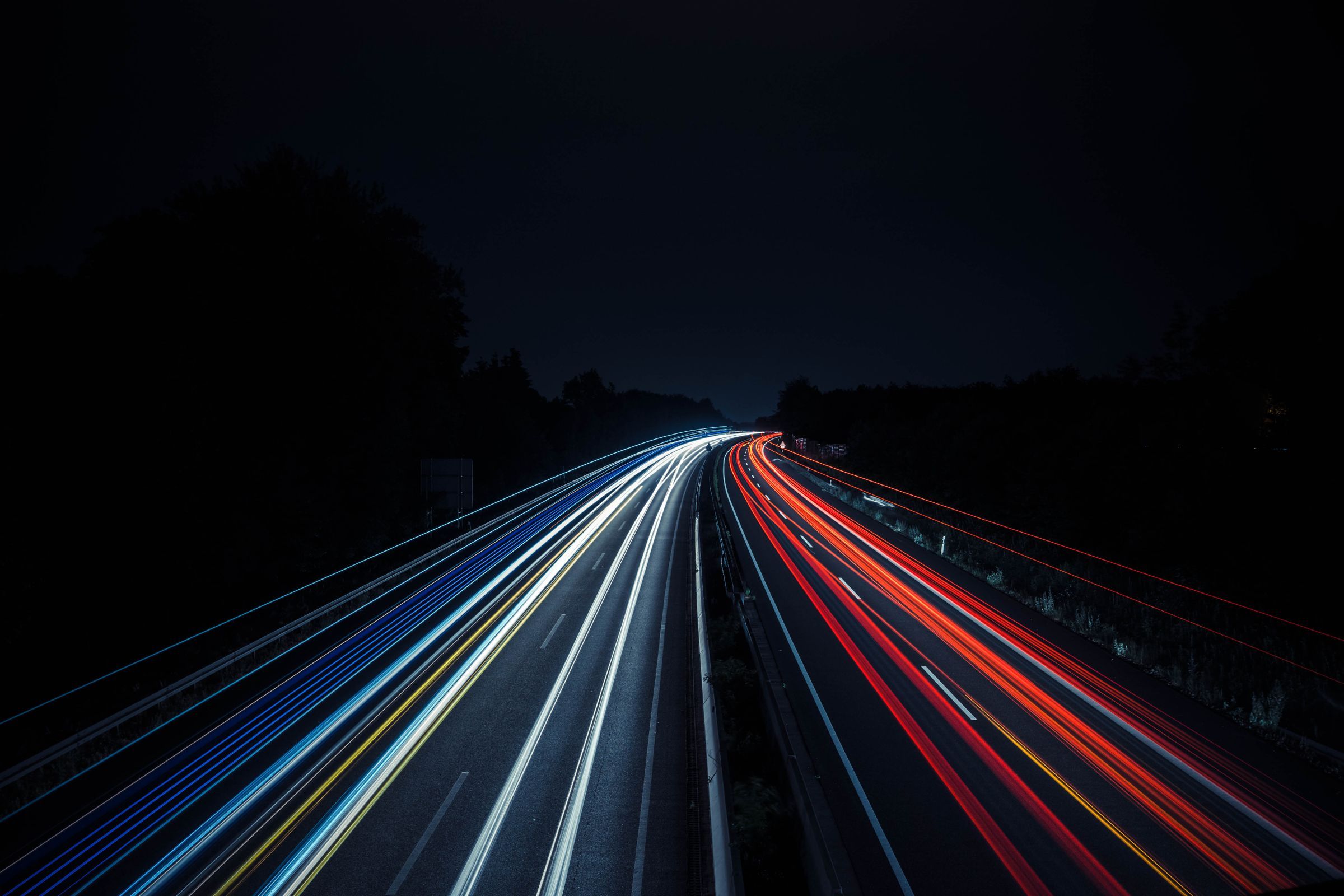Traînées lumineuses de véhicules sur une autoroute de nuit