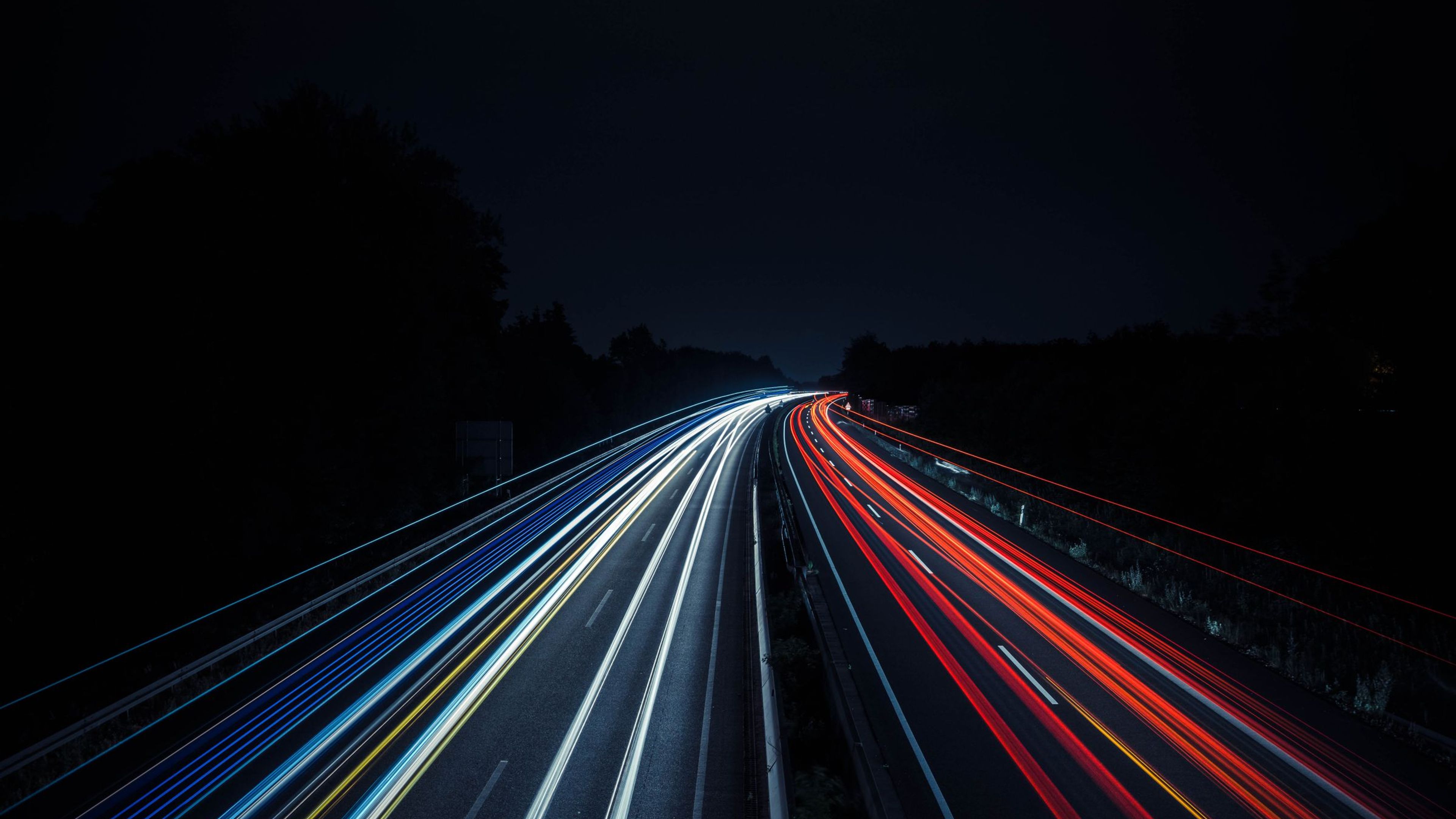 Estelas de luz de vehículos en una autopista de noche