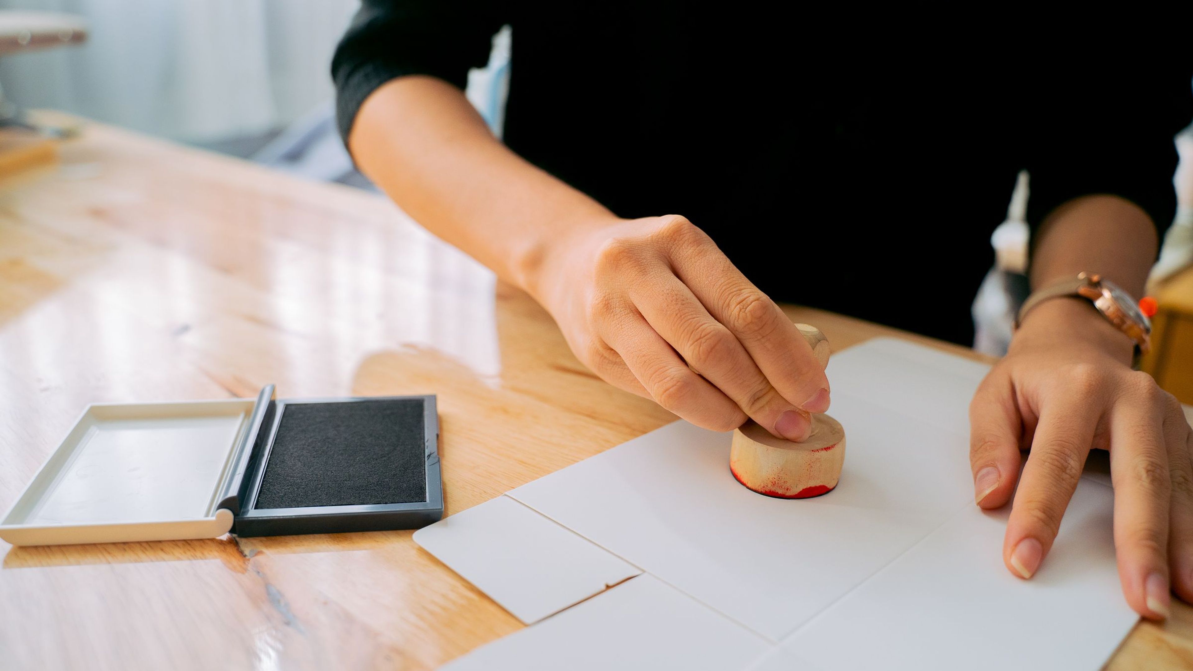 Mains apposant un tampon officiel sur un document