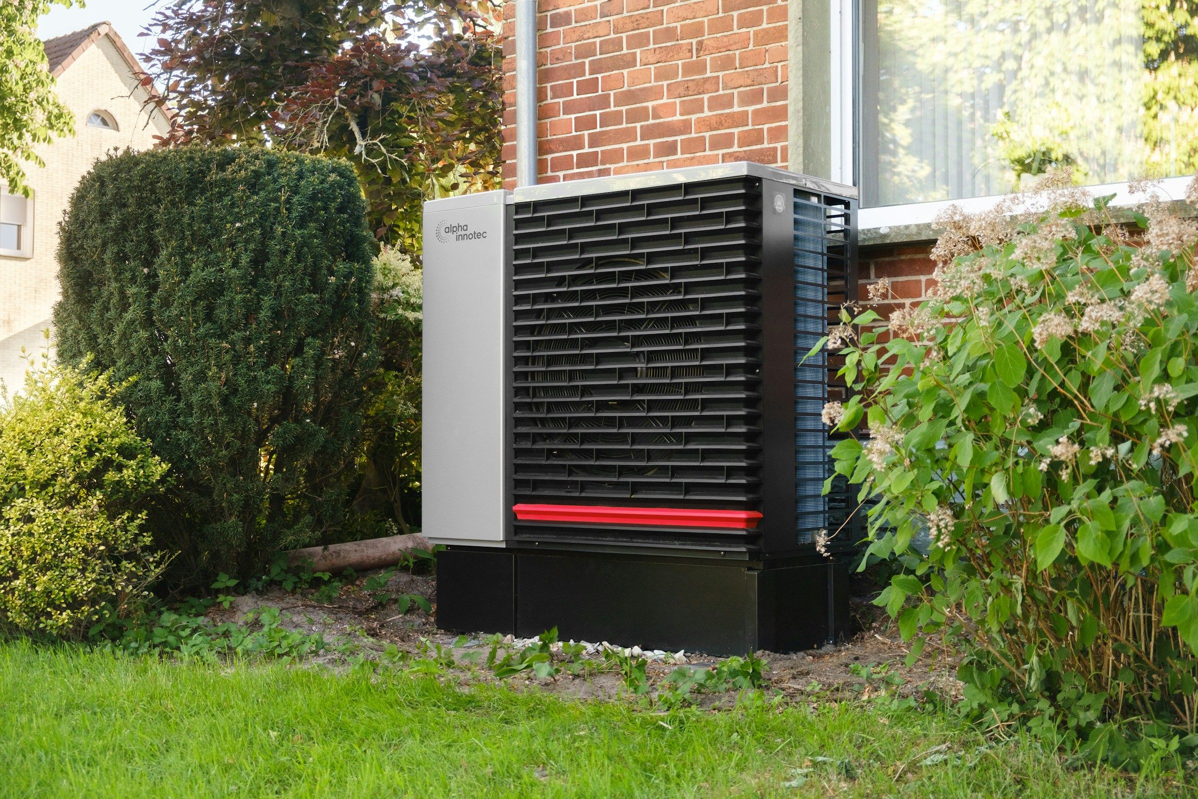 Air source heat pump installed beside a brick house