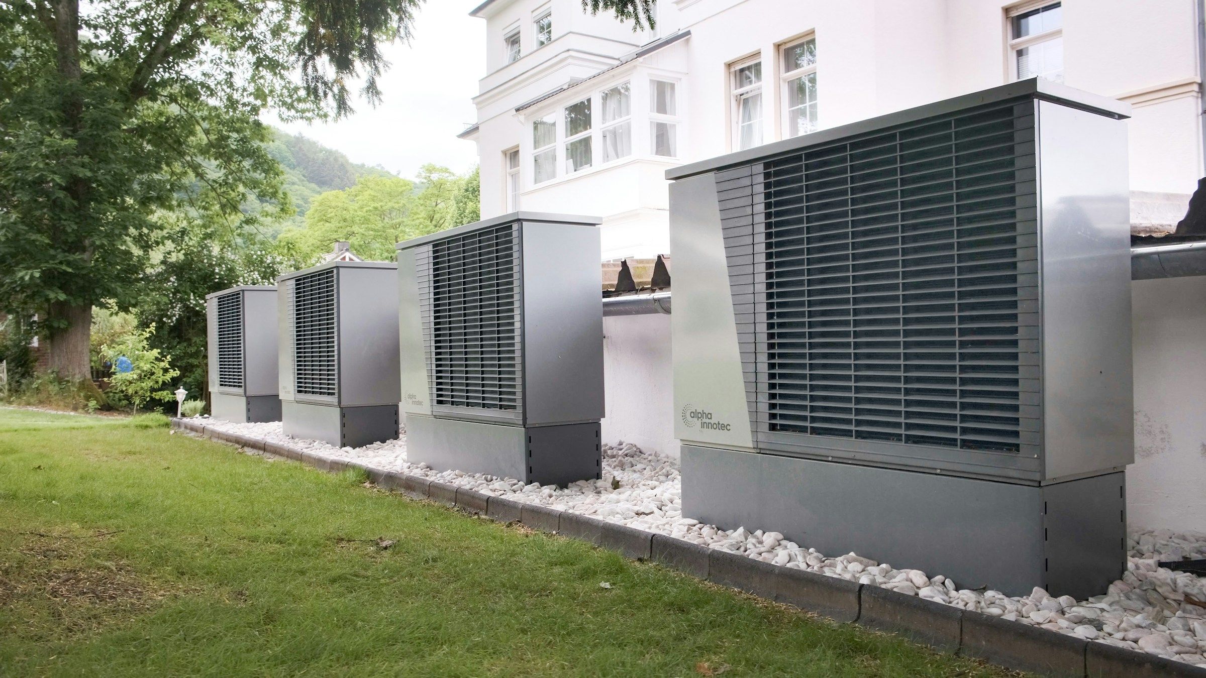 A row of large heat pump units outside a commercial building