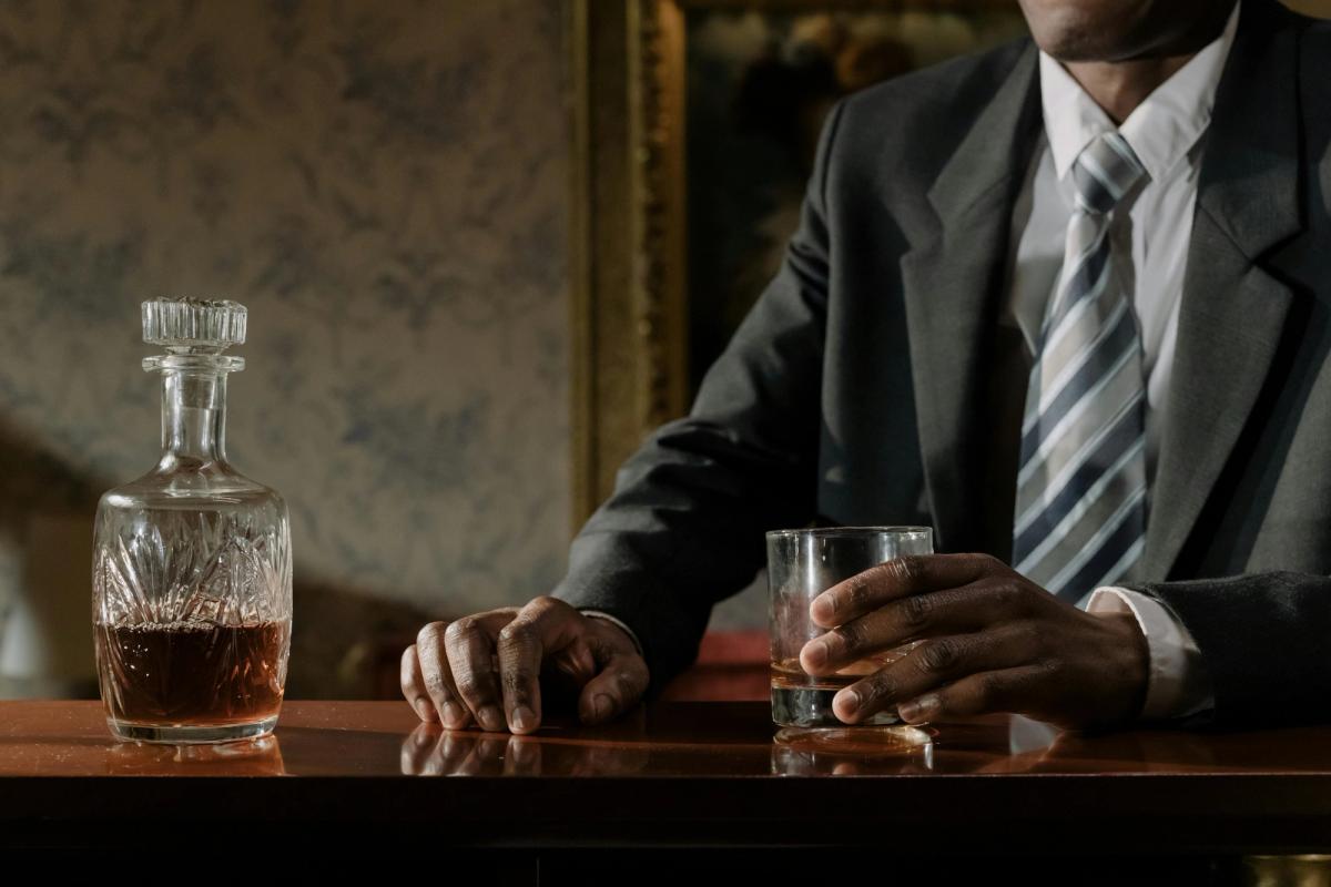 Man with whiskey glass at a table
