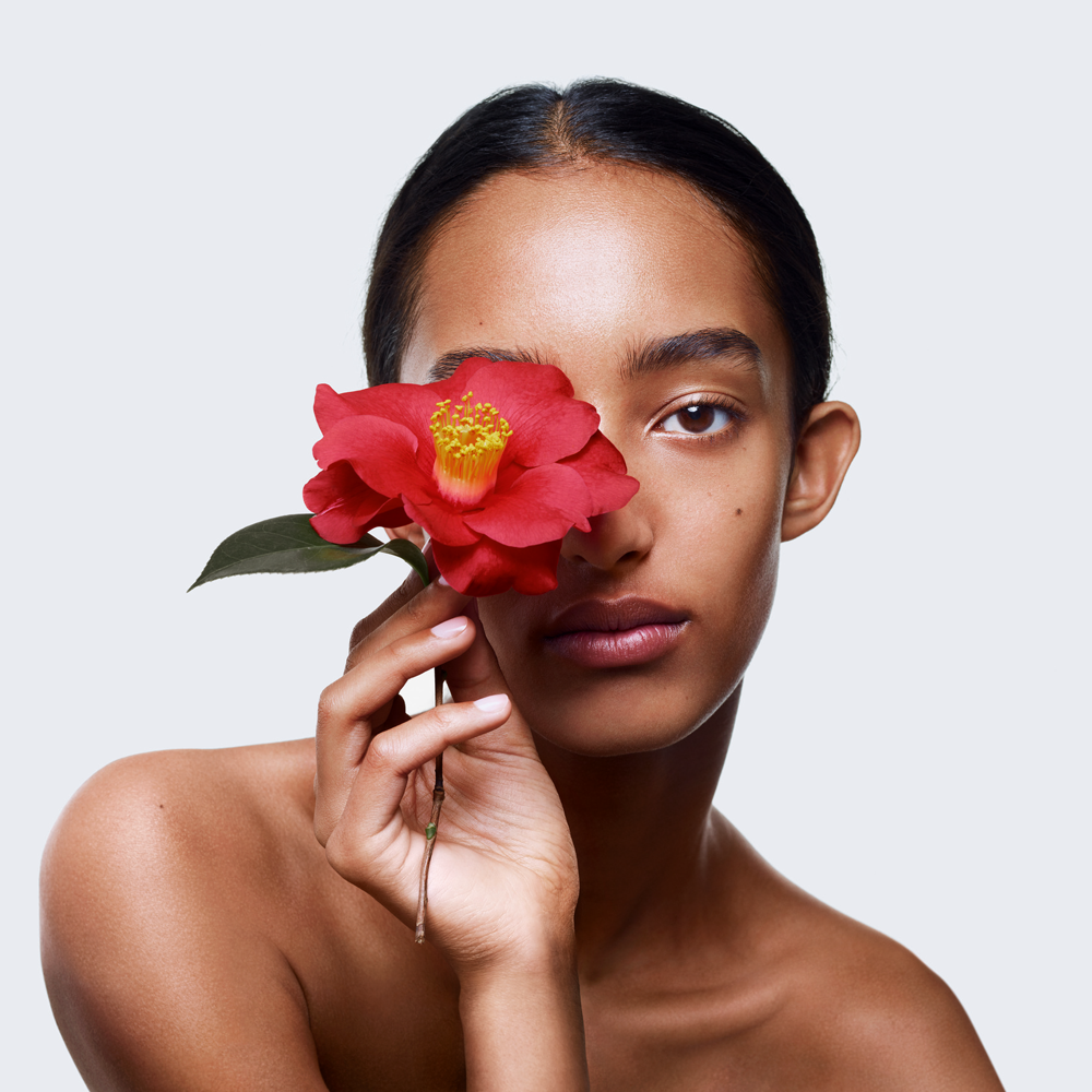Chanel model holding a red camellia flower. 