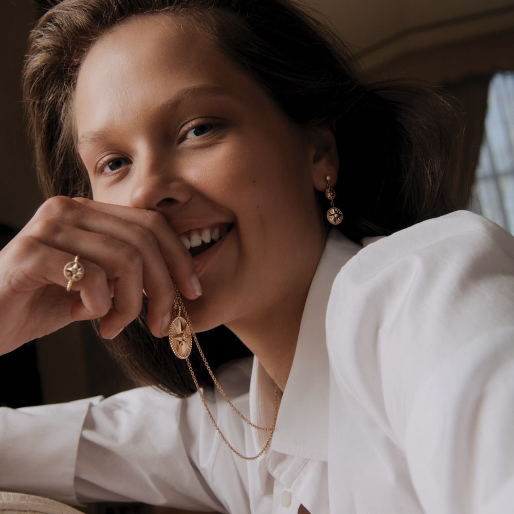 Model in a white shirt with gold jewellery. 