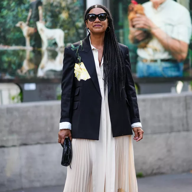 Woman at fashion week in a black blazer and cream outfit